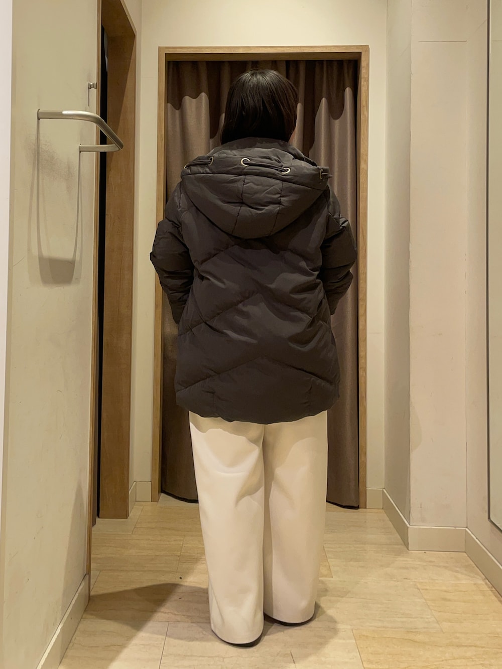 グレー系のダウンジャケット/コート、グレー系のニット/セーター、ホワイト系のその他パンツを着用したレディースの冬コーディネートの2枚目の写真