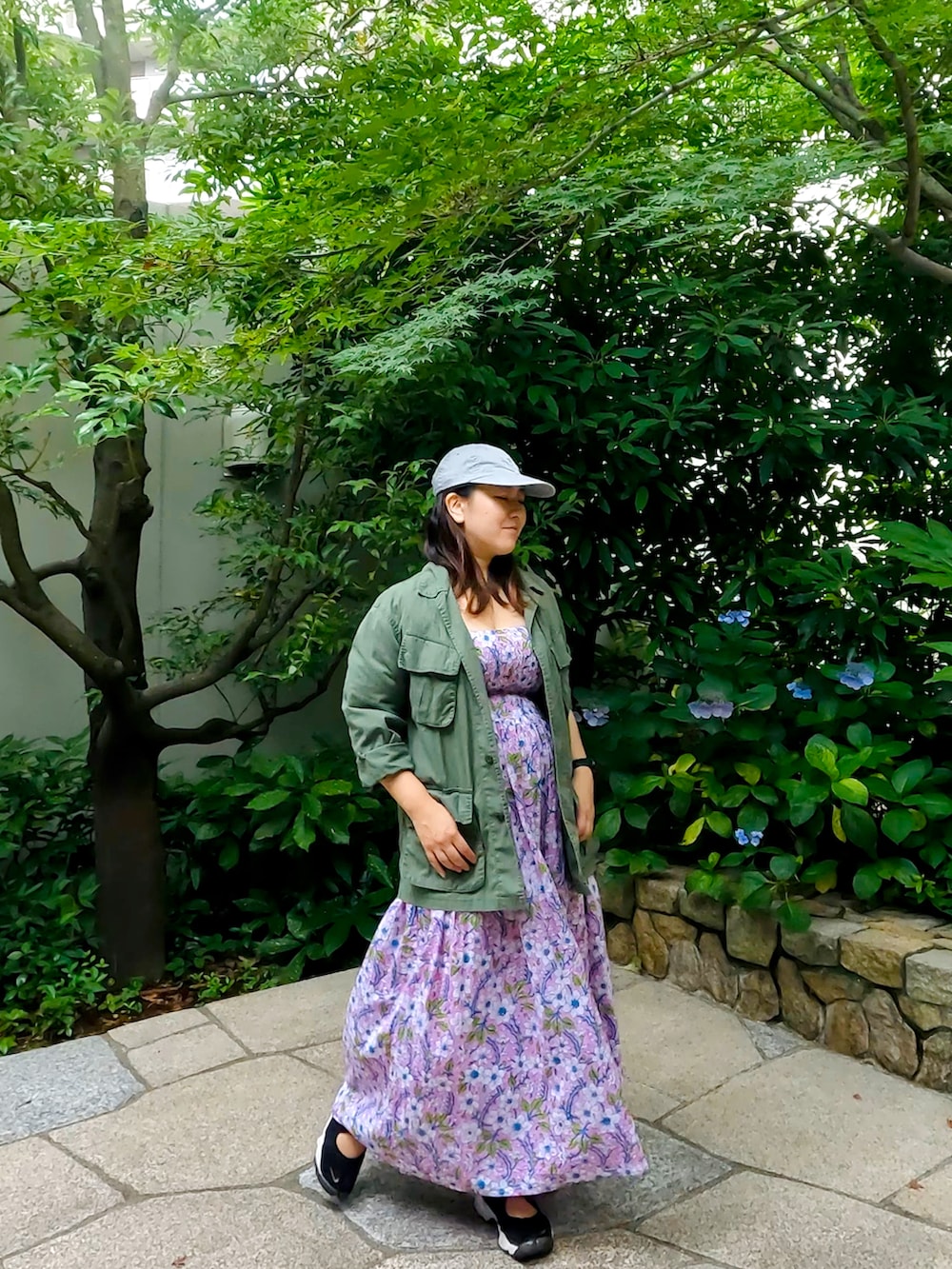 グリーン系のミリタリージャケット、パープル系のワンピース、ブラック系のサンダルを着用したレディースの夏コーディネートの2枚目の写真