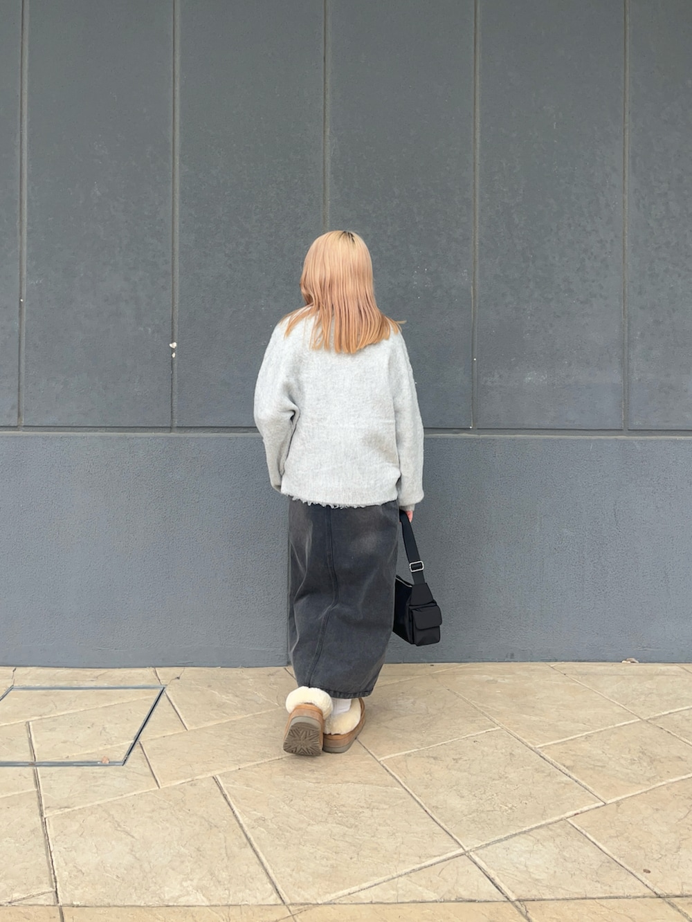 ホワイト系のカーディガン/ボレロ、ブラック系のデニムスカート、ブラック系のショルダーバッグを着用したレディースの冬コーディネートの4枚目の写真