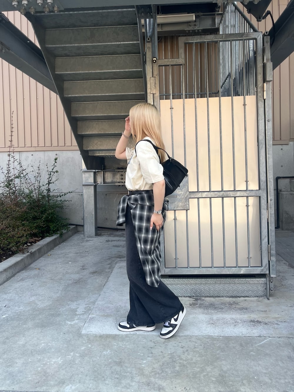 ホワイト系のTシャツ/カットソー、ブラック系のボストンバッグ、ブラック系のデニムパンツを着用したレディースの春コーディネートの2枚目の写真