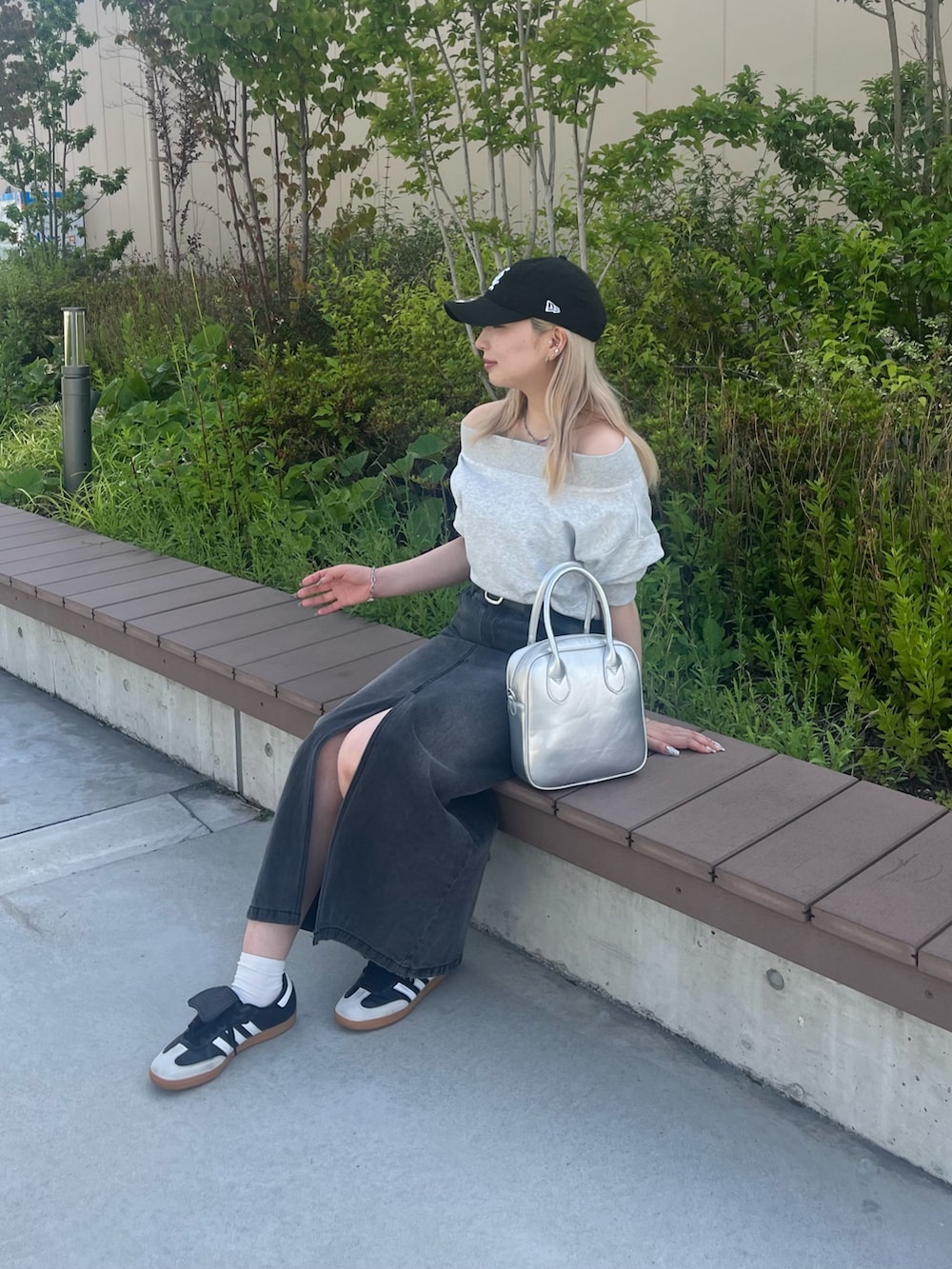 グレー系のスウェット、ブラック系のデニムスカート、ブラック系のベルトを着用したレディースの夏コーディネートの3枚目の写真