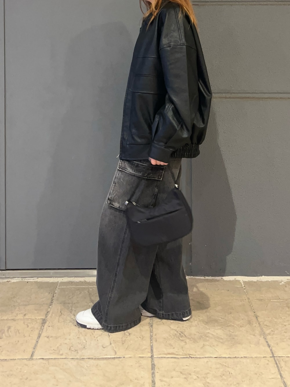 ホワイト系のTシャツ/カットソー、ブラック系のブルゾン、ブラック系のデニムパンツを着用したレディースの秋コーディネートの2枚目の写真