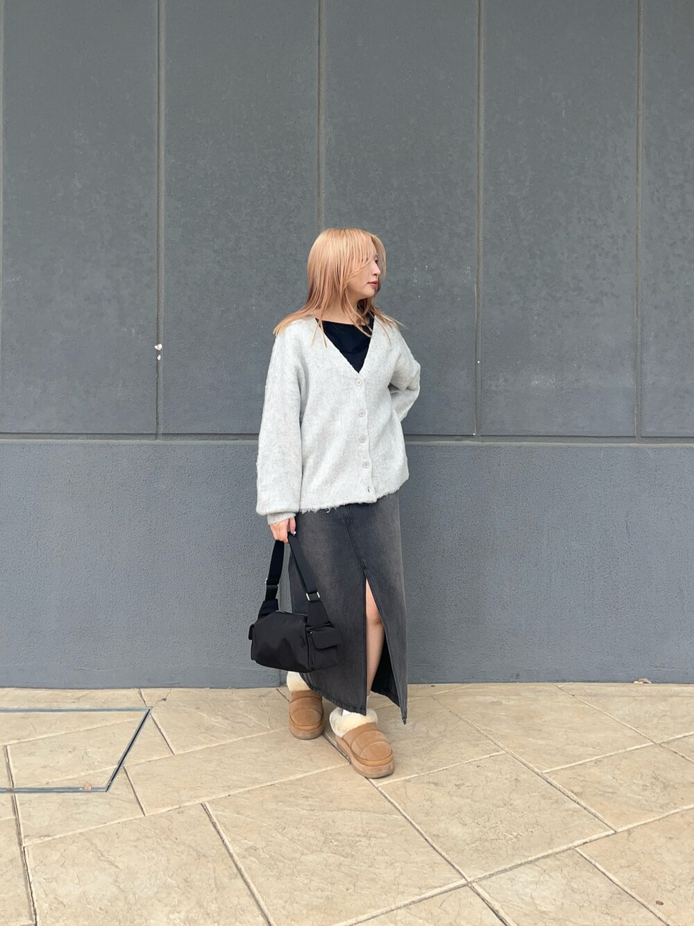 ホワイト系のカーディガン/ボレロ、ブラック系のデニムスカート、ブラック系のショルダーバッグを着用したレディースの冬コーディネートの2枚目の写真