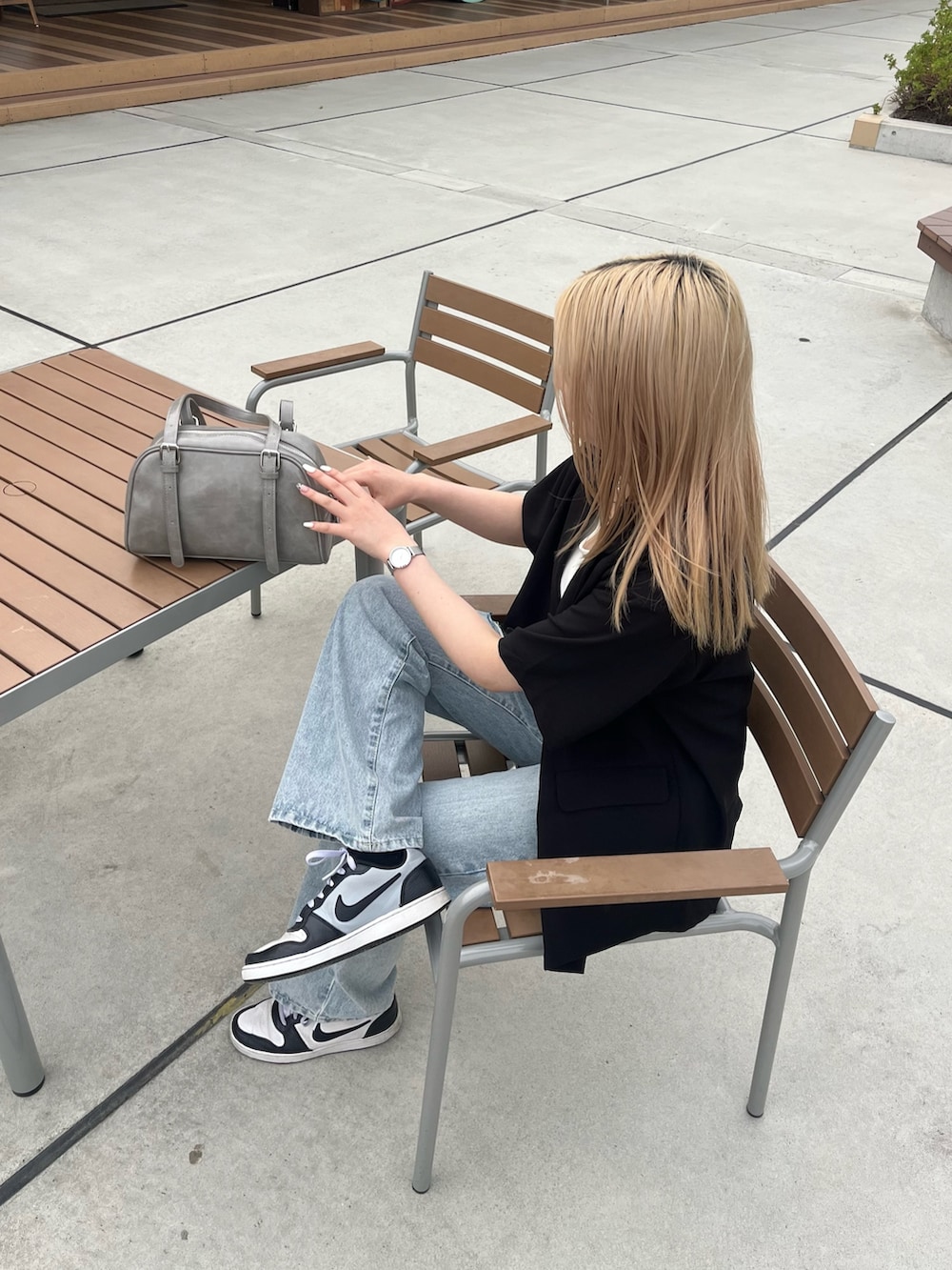 ブラック系のテーラードジャケット、ホワイト系のTシャツ/カットソー、グレー系のボストンバッグを着用したレディースの春コーディネートの2枚目の写真