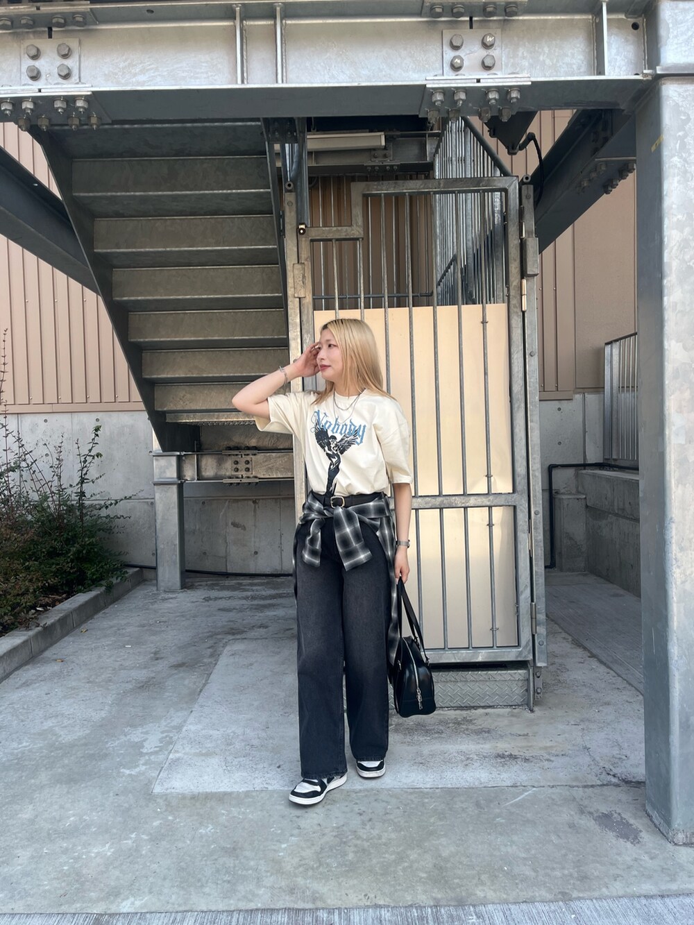 ホワイト系のTシャツ/カットソー、ブラック系のボストンバッグ、ブラック系のデニムパンツを着用したレディースの春コーディネートの3枚目の写真