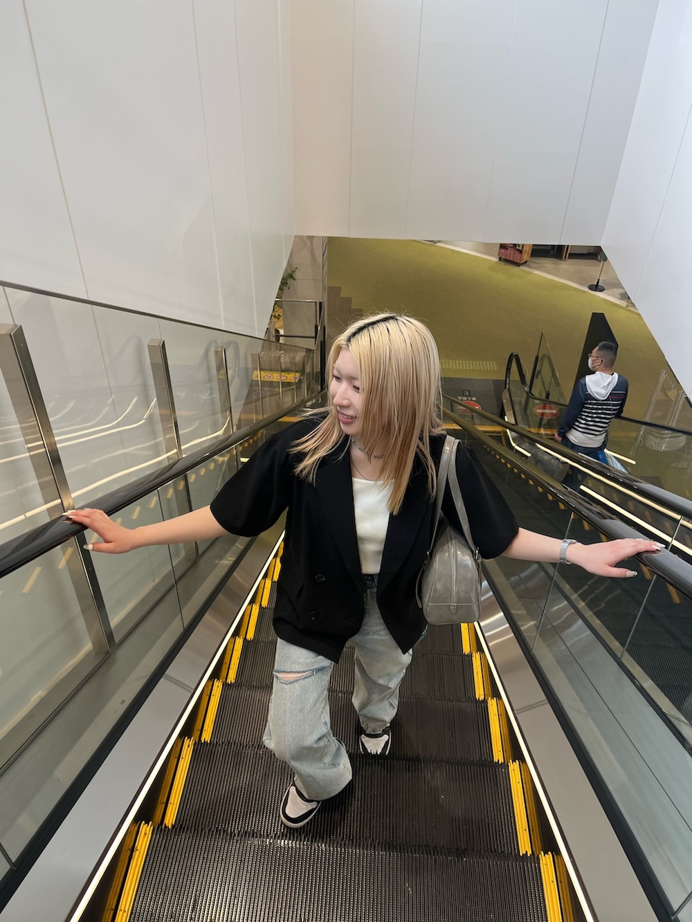 ブラック系のテーラードジャケット、ホワイト系のTシャツ/カットソー、グレー系のボストンバッグを着用したレディースの春コーディネートの3枚目の写真