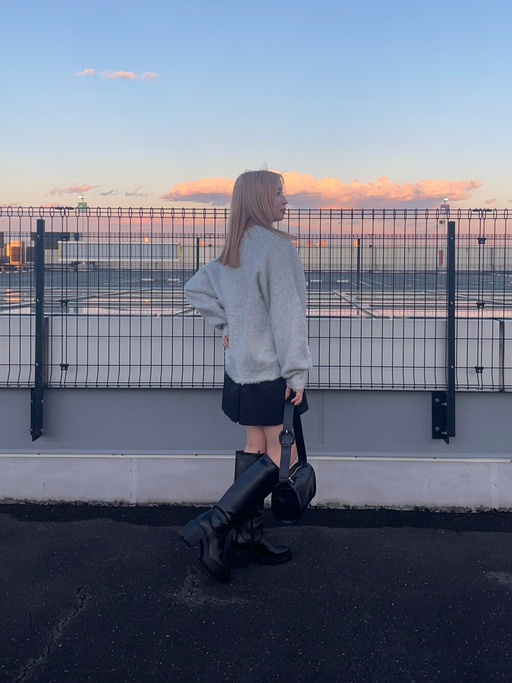 ホワイト系のカーディガン/ボレロ、ブラック系のブーツ、ブラック系のドラムバッグを着用したレディースの冬コーディネートの2枚目の写真