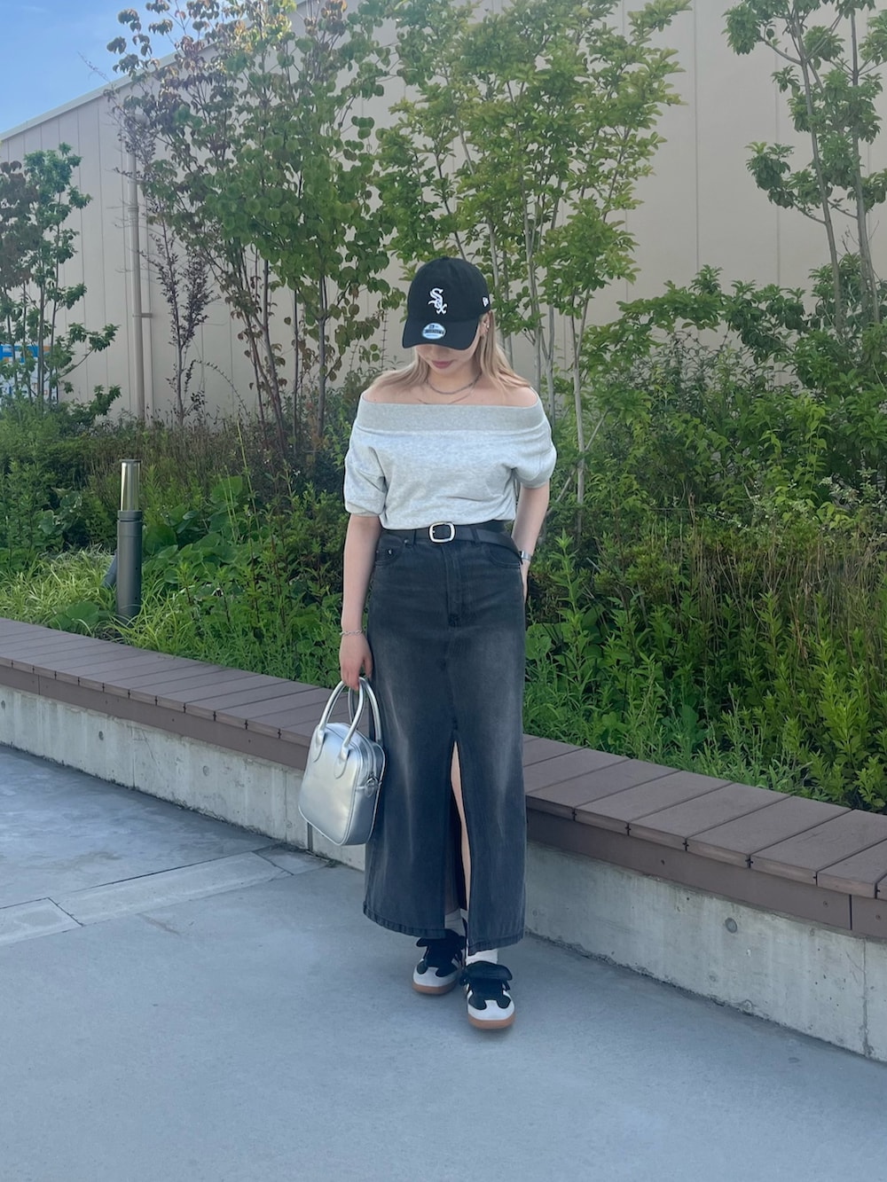 グレー系のスウェット、ブラック系のデニムスカート、ブラック系のベルトを着用したレディースの夏コーディネートの4枚目の写真