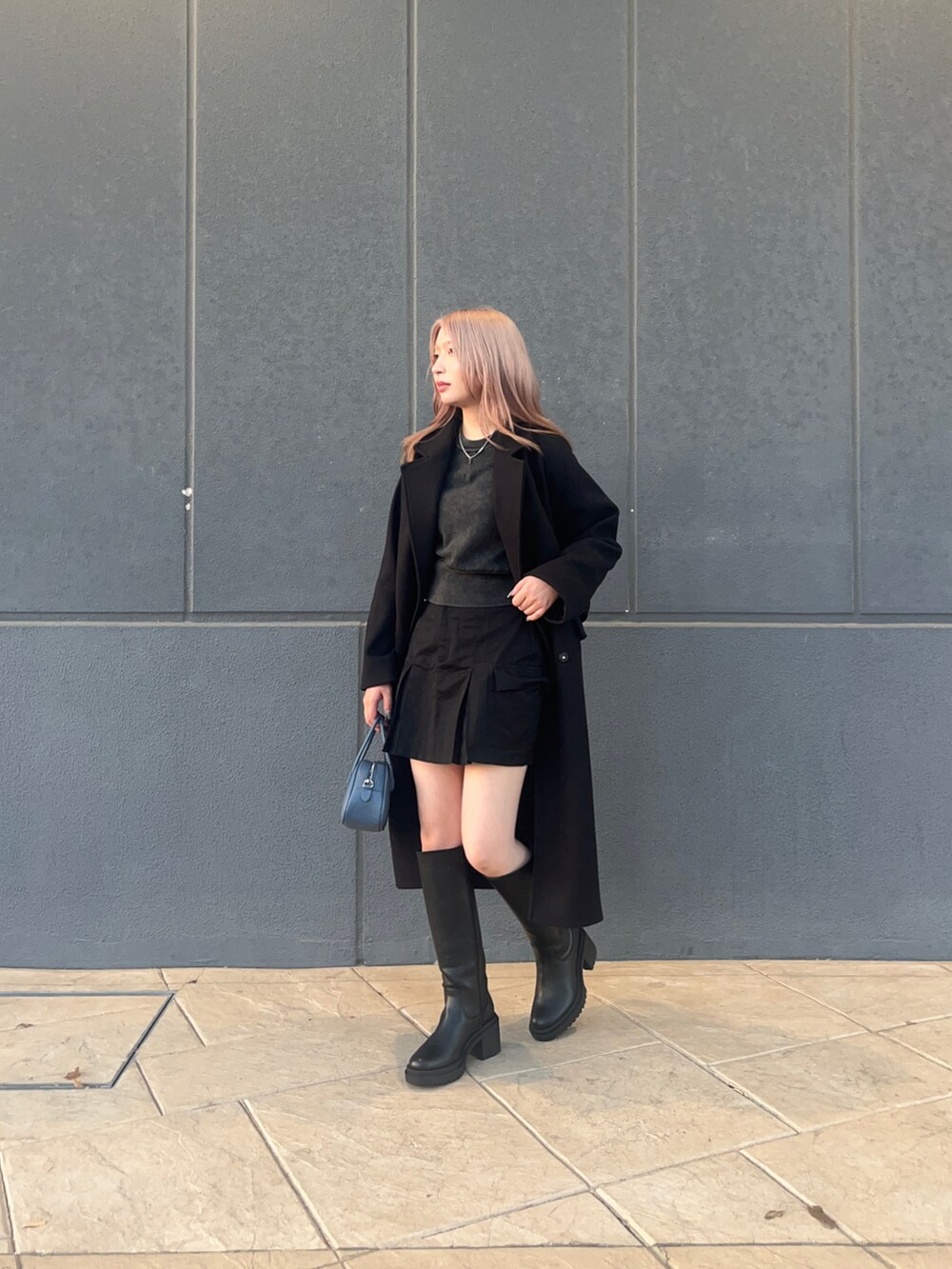 ブラック系のその他アウター、ブラック系のブーツ、グレー系のニット/セーターを着用したレディースの秋コーディネートの2枚目の写真