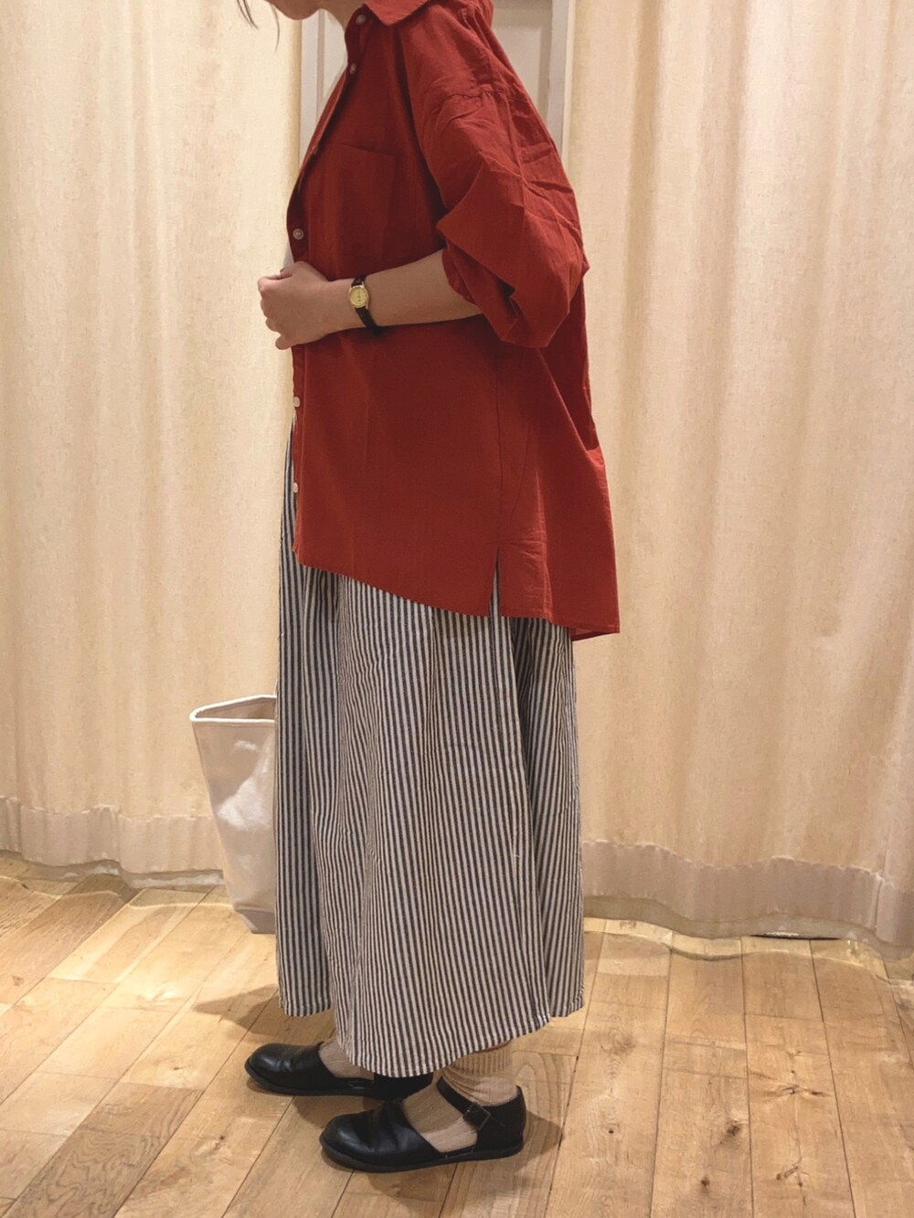 レッド系のシャツ/ブラウス、ホワイト系のTシャツ/カットソー、ブラック系のパンツを着用したレディースの春コーディネートの2枚目の写真