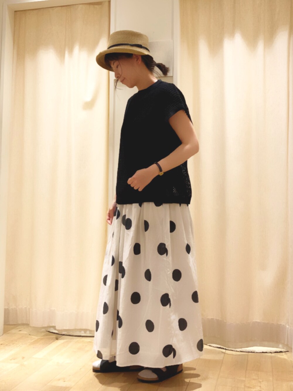 ブラック系のTシャツ/カットソー、ベージュ系のスカート、ブラック系のベストを着用したレディースの夏コーディネートの2枚目の写真