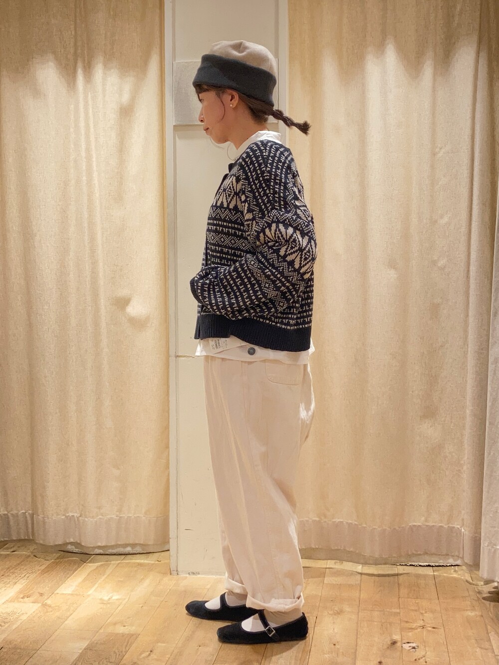 グレー系のハンドバッグ、ホワイト系のシャツ/ブラウス、ブラック系のカーディガン/ボレロを着用したレディースの秋コーディネートの2枚目の写真