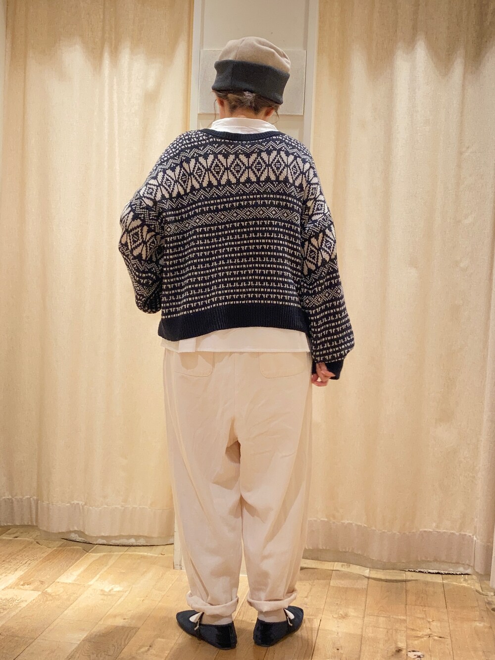 グレー系のハンドバッグ、ホワイト系のシャツ/ブラウス、ブラック系のカーディガン/ボレロを着用したレディースの秋コーディネートの3枚目の写真