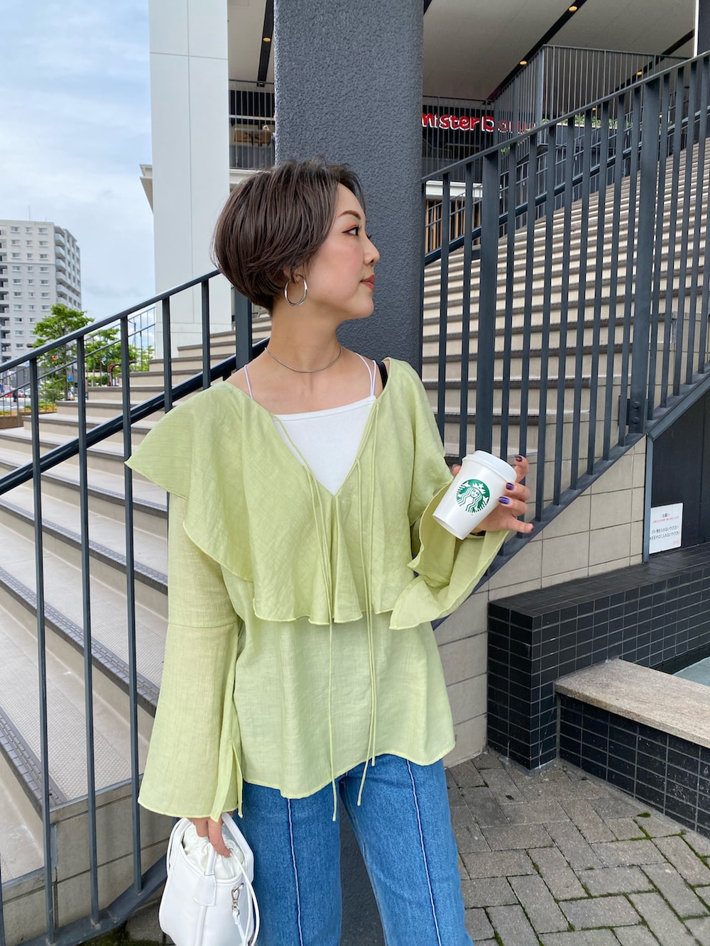 グリーン系のシャツ/ブラウス、ブルー系のデニムパンツ、ホワイト系のショルダーバッグを着用したレディースの夏コーディネートの2枚目の写真