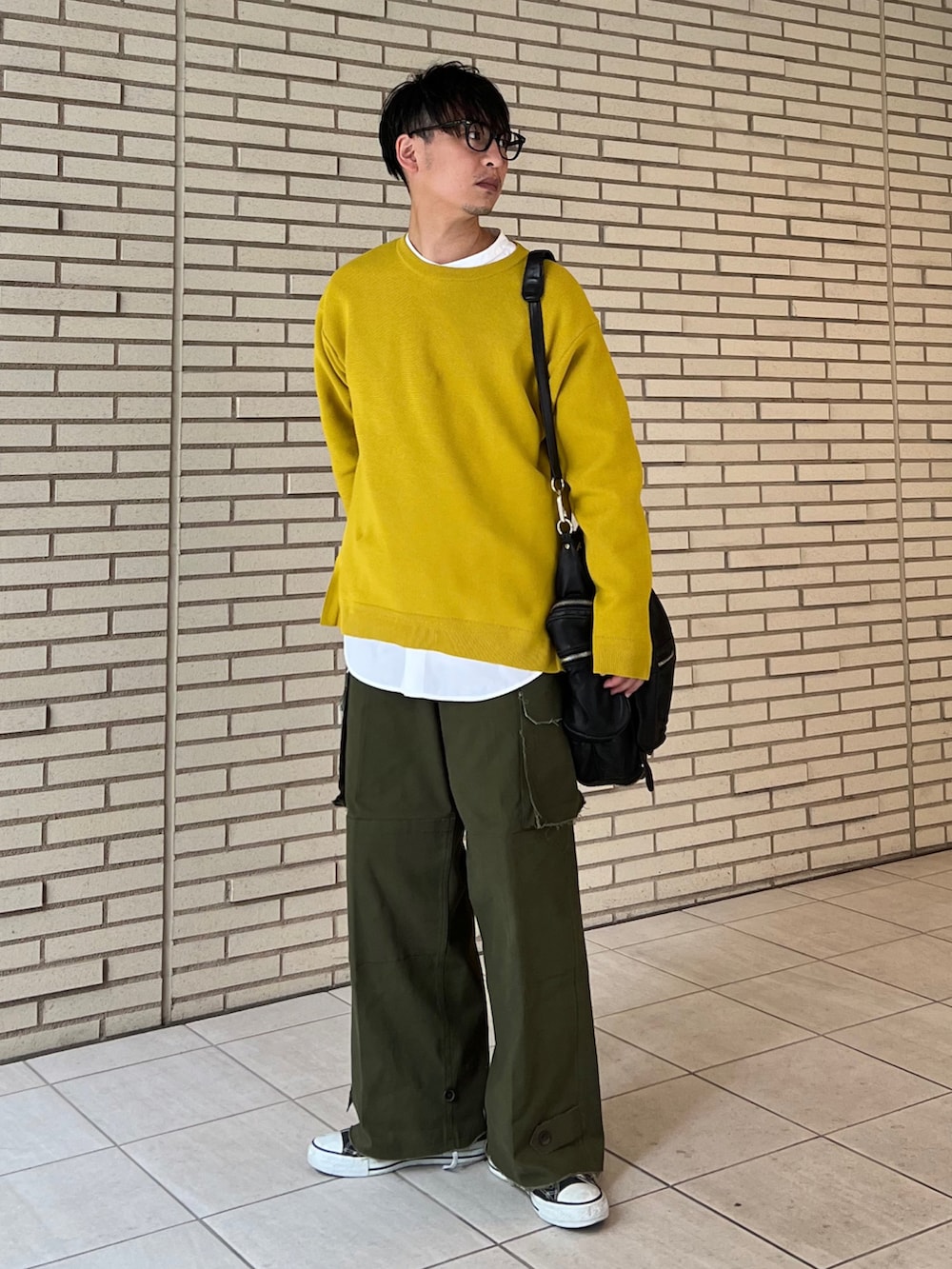 オレンジ系のニット/セーター、ホワイト系のシャツ/ブラウス、グリーン系のカーゴパンツを着用したメンズの冬コーディネートの2枚目の写真