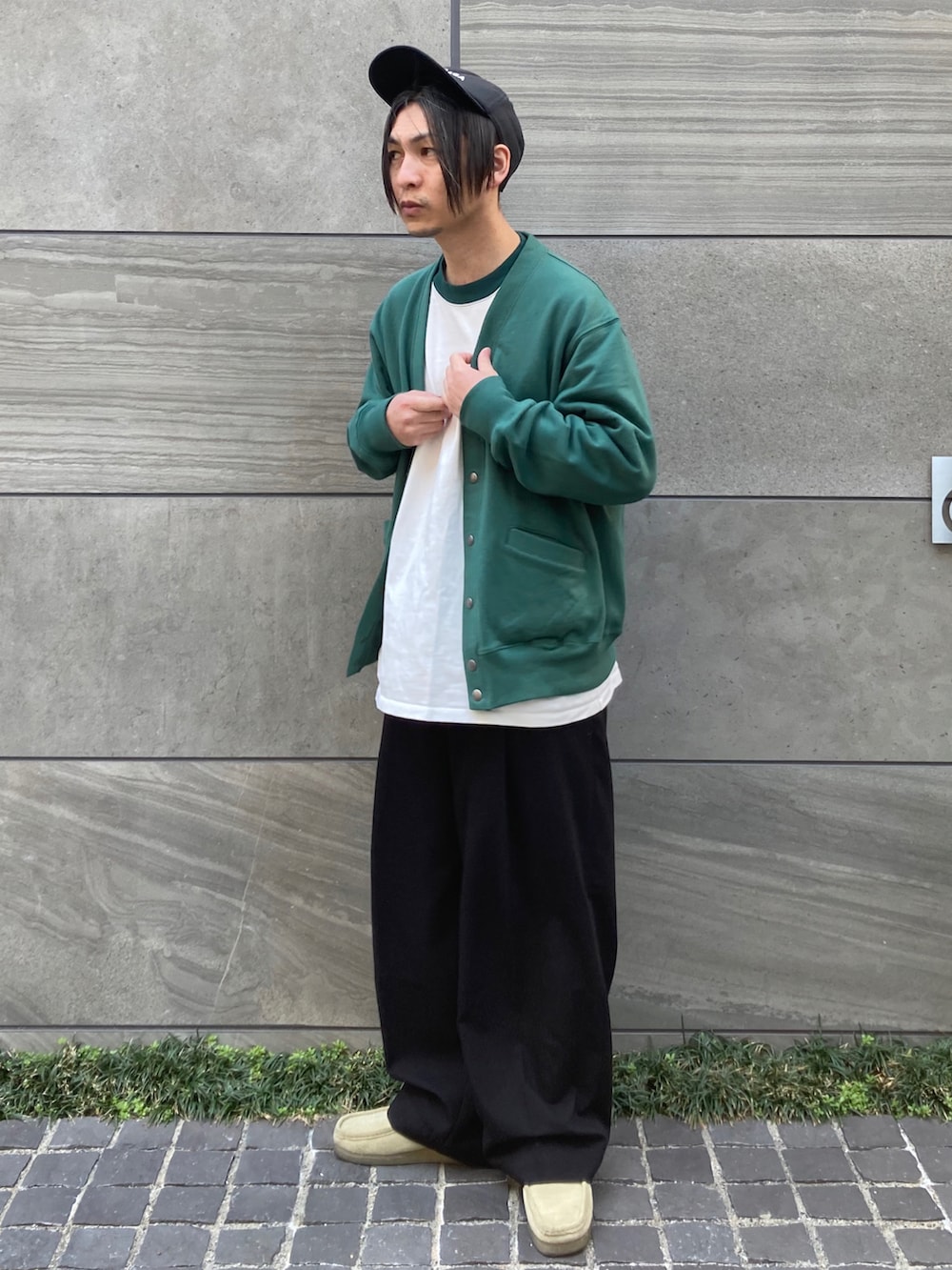 グリーン系のカーディガン/ボレロ、グリーン系のTシャツ/カットソー、ブラック系のスラックスを着用したメンズの春コーディネートの2枚目の写真