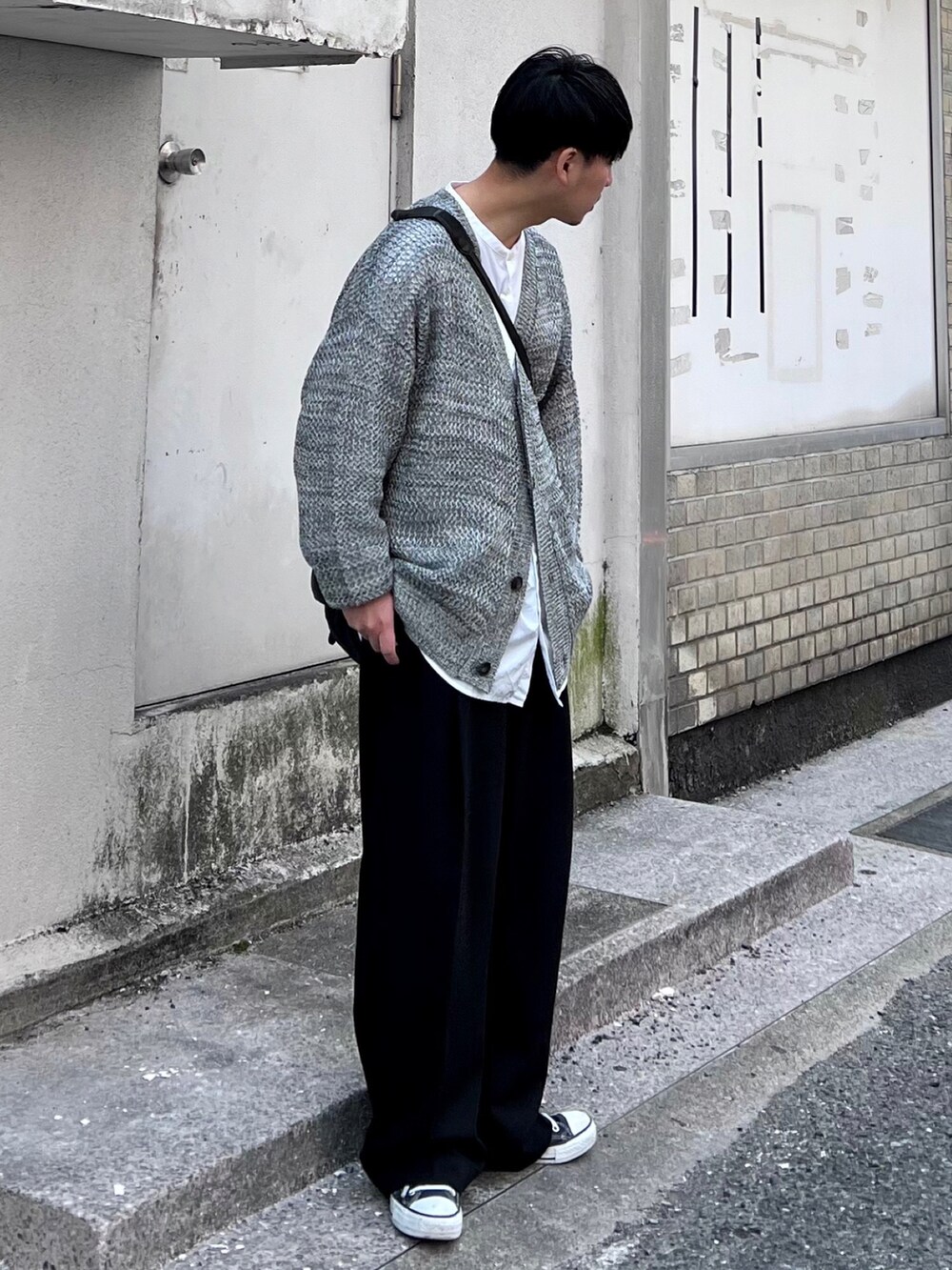 グレー系のカーディガン/ボレロ、ブラック系のスラックスを着用したメンズの春コーディネートの2枚目の写真