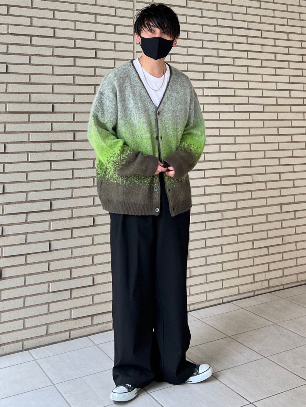 グリーン系のカーディガン/ボレロ、ホワイト系のTシャツ/カットソー、ブラック系のスラックスを着用したメンズの秋コーディネートの4枚目の写真