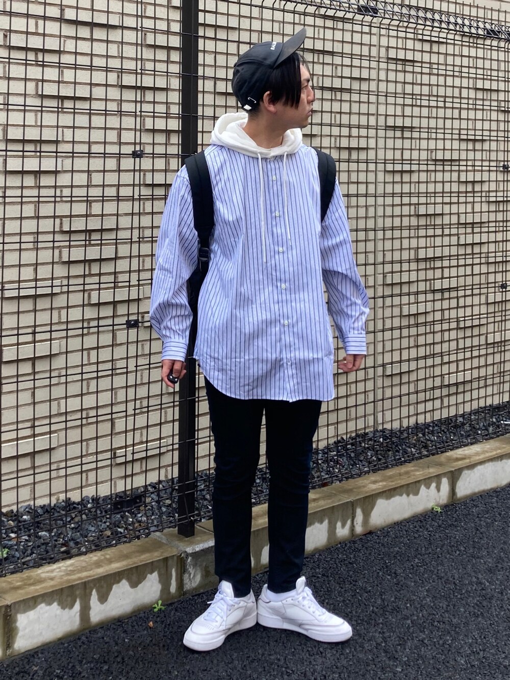 ブラック系のデニムパンツ、ブルー系のシャツ/ブラウス、ホワイト系のスニーカーを着用したメンズの春コーディネートの2枚目の写真