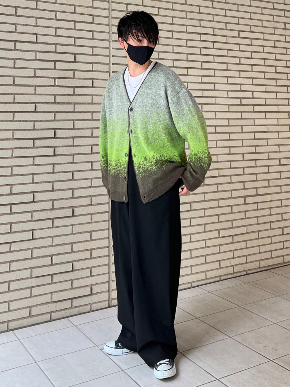 グリーン系のカーディガン/ボレロ、ホワイト系のTシャツ/カットソー、ブラック系のスラックスを着用したメンズの秋コーディネートの3枚目の写真