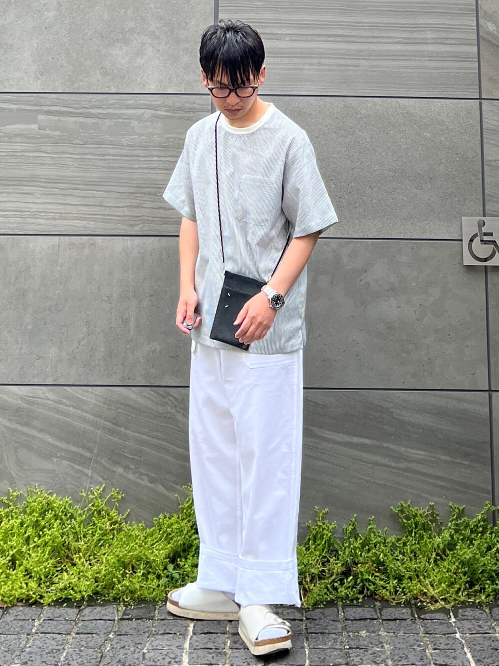ブルー系のTシャツ/カットソー、ブラック系のショルダーバッグ、ホワイト系のパンツを着用したメンズの夏コーディネートの2枚目の写真