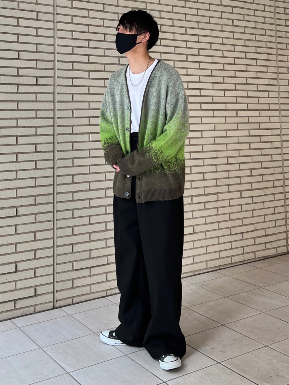 グリーン系のカーディガン/ボレロ、ホワイト系のTシャツ/カットソー、ブラック系のスラックスを着用したメンズの秋コーディネートの2枚目の写真