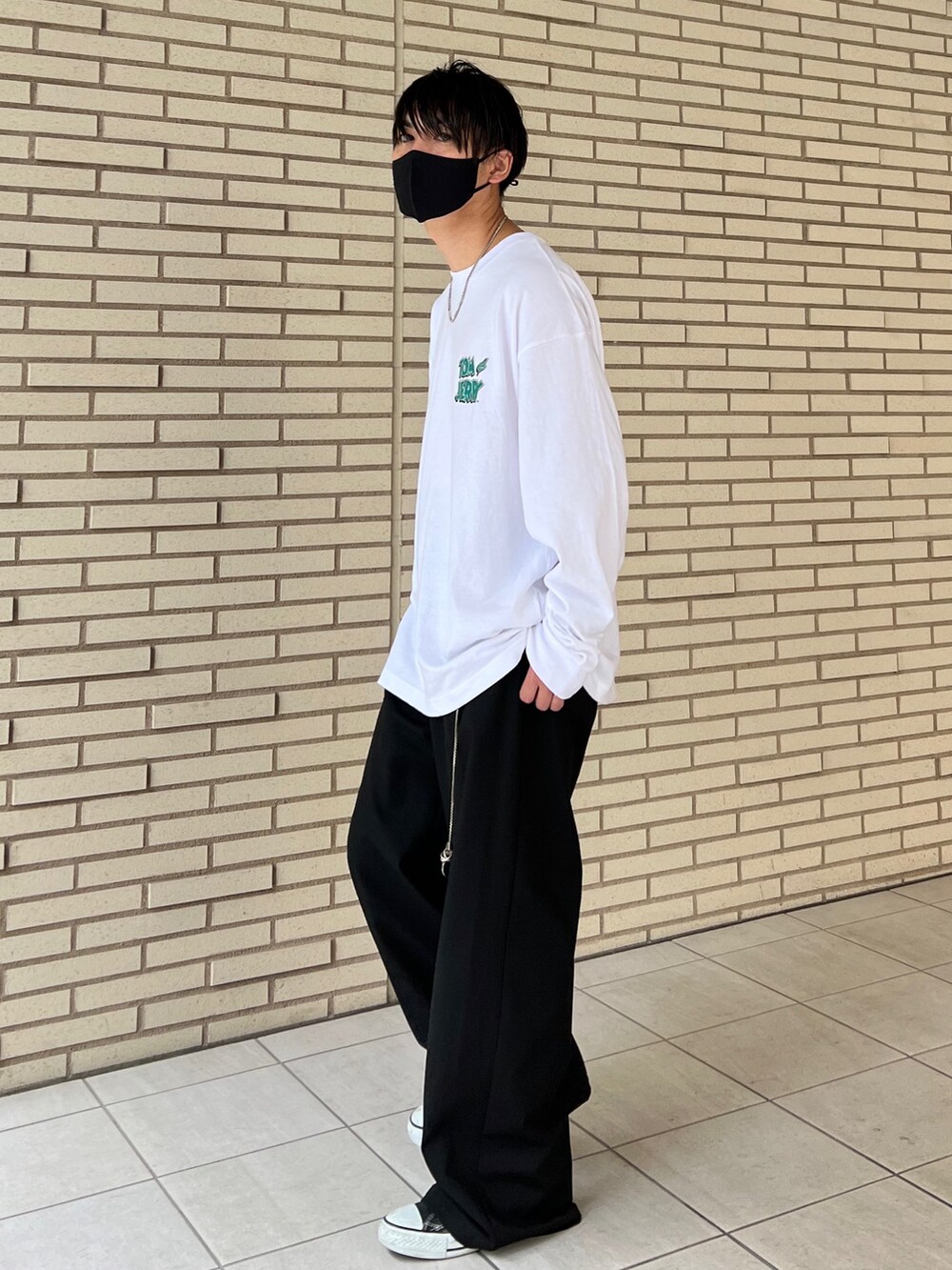 ホワイト系のTシャツ/カットソー、ブラック系のスラックス、ブラック系のスニーカーを着用したメンズの秋コーディネートの4枚目の写真