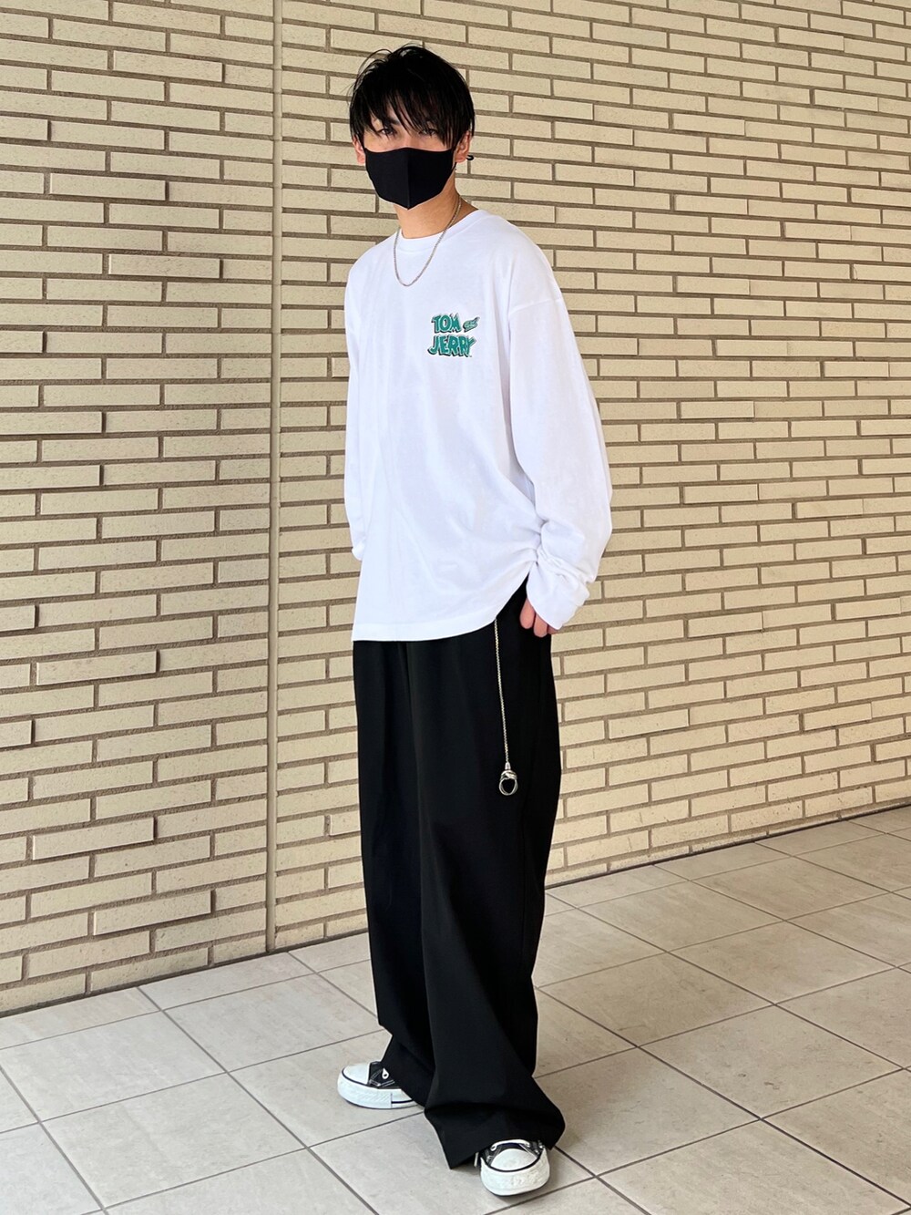 ホワイト系のTシャツ/カットソー、ブラック系のスラックス、ブラック系のスニーカーを着用したメンズの秋コーディネートの3枚目の写真