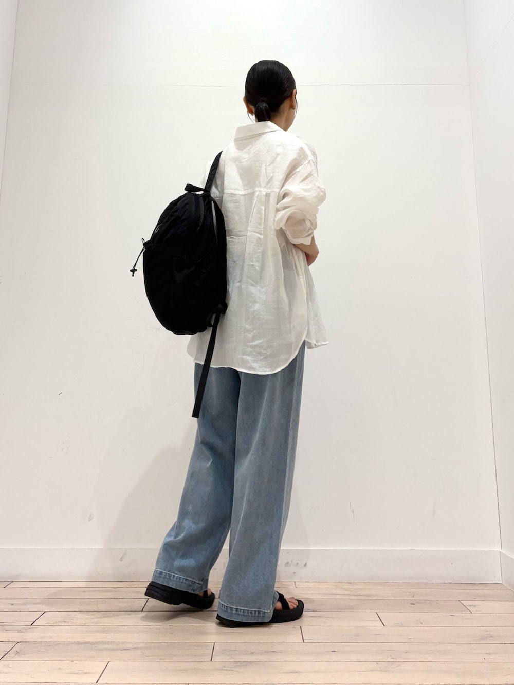ホワイト系のシャツ/ブラウス、ホワイト系のタンクトップ、ブラック系のバックパック/リュックを着用したレディースの夏コーディネートの3枚目の写真