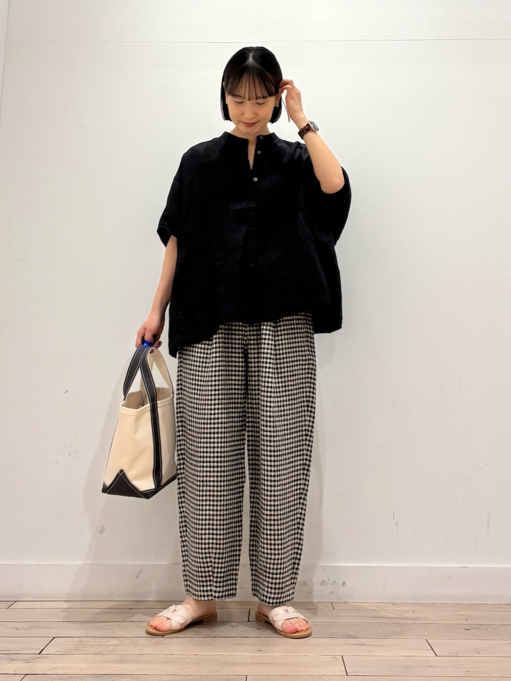 ブラック系のシャツ/ブラウス、ブラック系のその他パンツ、グレー系のトートバッグを着用したレディースの春コーディネートの2枚目の写真