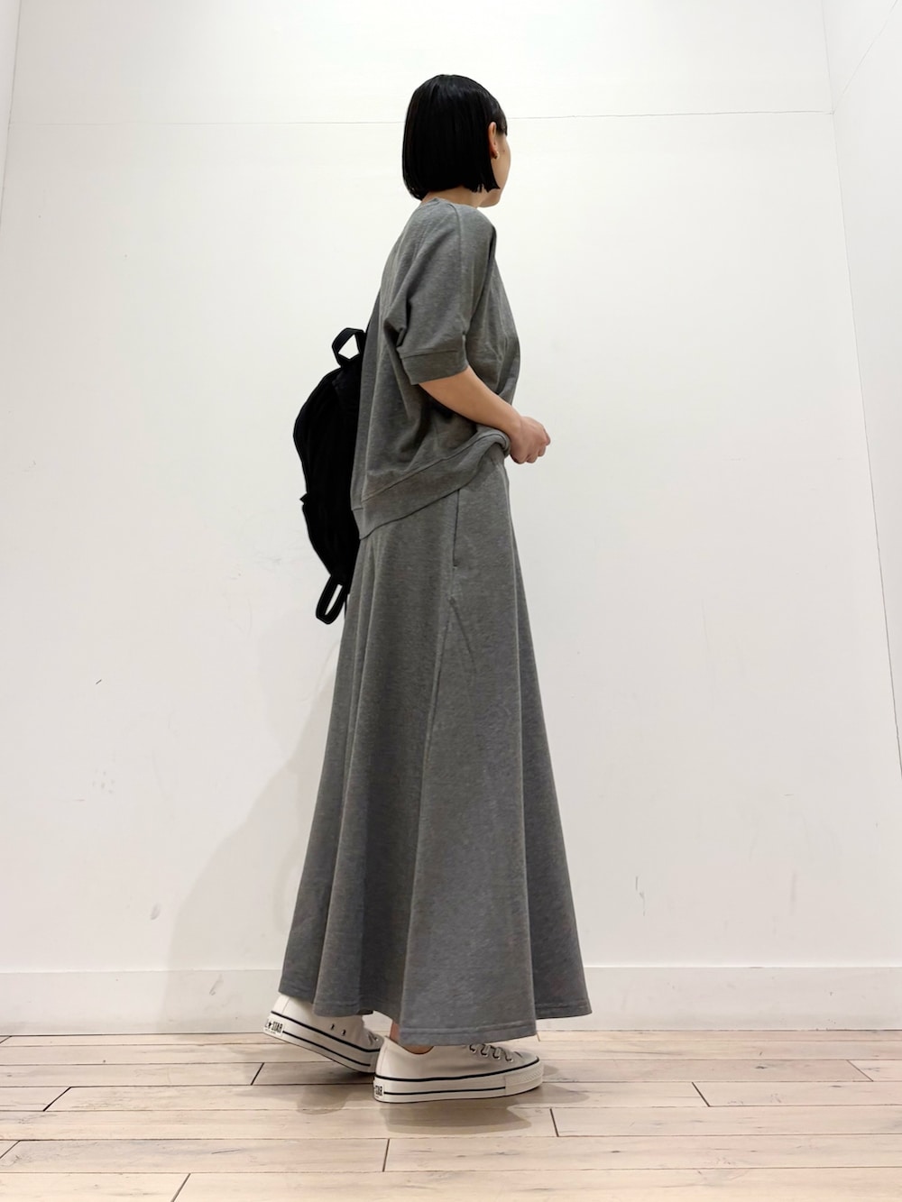 グレー系のTシャツ/カットソー、グレー系のスカート、ホワイト系のスニーカーを着用したレディースの春コーディネートの3枚目の写真