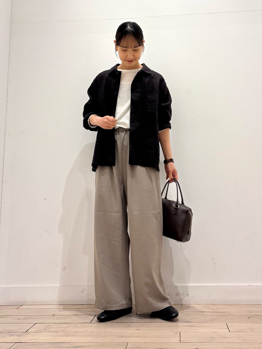 グレー系のカバーオール、グレー系のその他パンツ、ブラウン系のボストンバッグを着用したレディースの春コーディネートの2枚目の写真