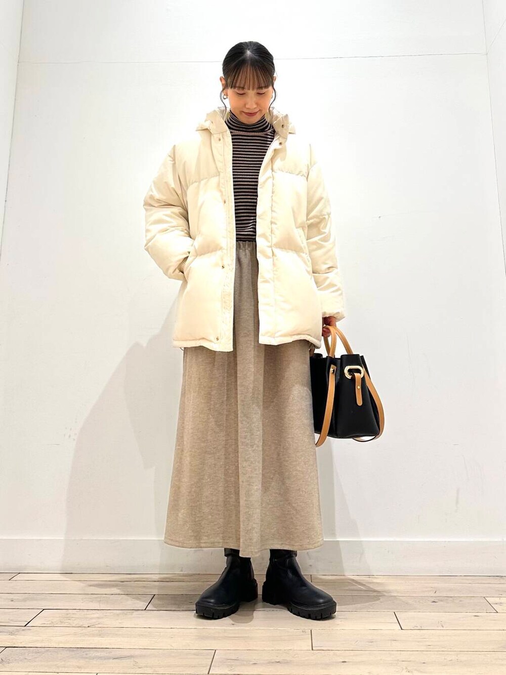 ブラック系のトートバッグ、ブラック系のブーツ、その他のニット/セーターを着用したレディースの冬コーディネートの4枚目の写真