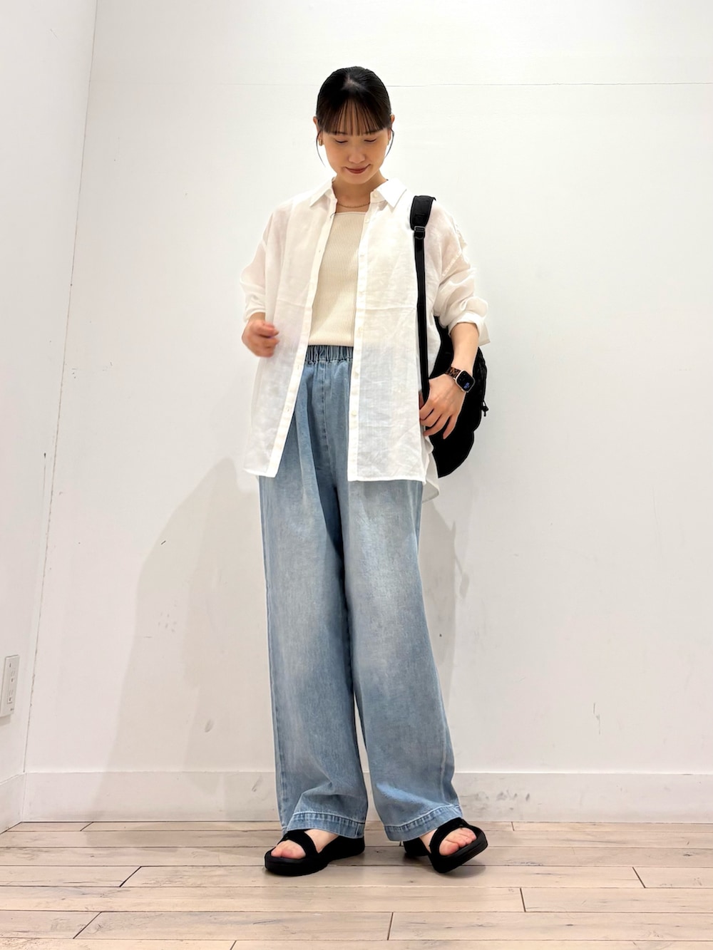 ホワイト系のシャツ/ブラウス、ホワイト系のタンクトップ、ブラック系のバックパック/リュックを着用したレディースの夏コーディネートの2枚目の写真