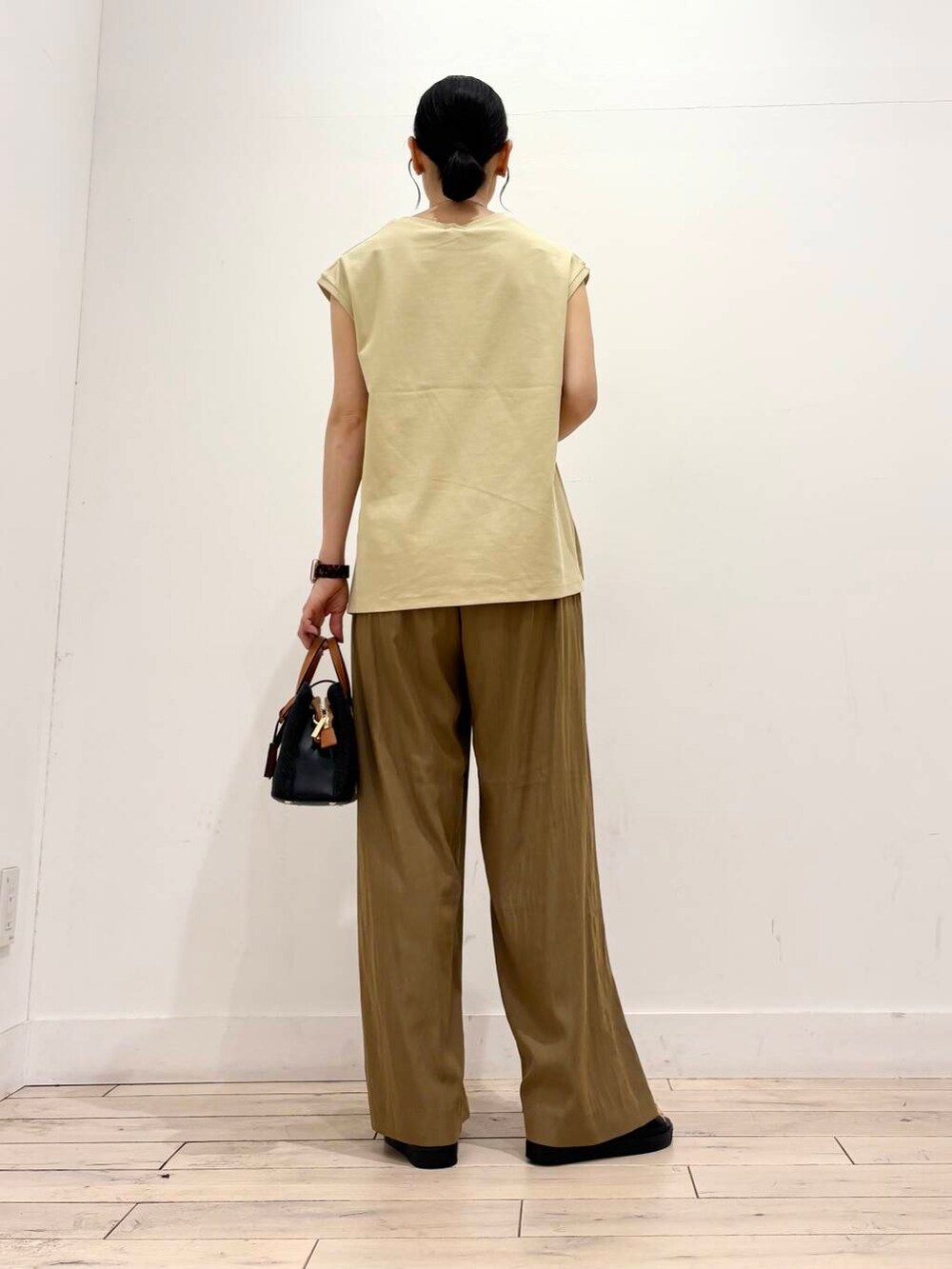 ブラック系のトートバッグ、ブラック系のサンダル、グリーン系のその他パンツを着用したレディースの夏コーディネートの4枚目の写真