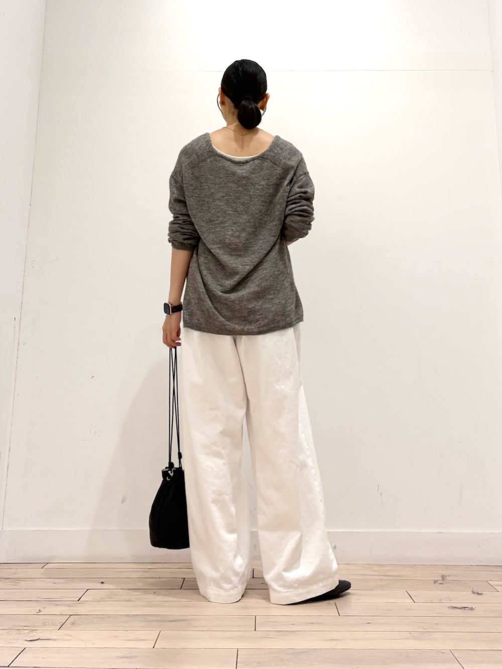 グレー系のニット/セーター、ホワイト系のその他パンツ、ブラック系のショルダーバッグを着用したレディースの秋コーディネートの4枚目の写真