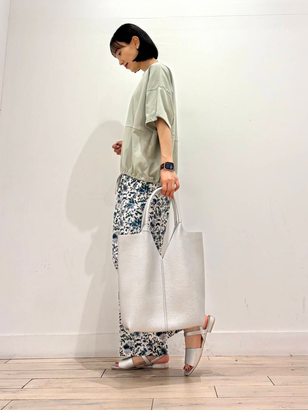 シルバー系のトートバッグ、グリーン系のTシャツ/カットソー、ブルー系のその他パンツを着用したレディースの夏コーディネートの3枚目の写真