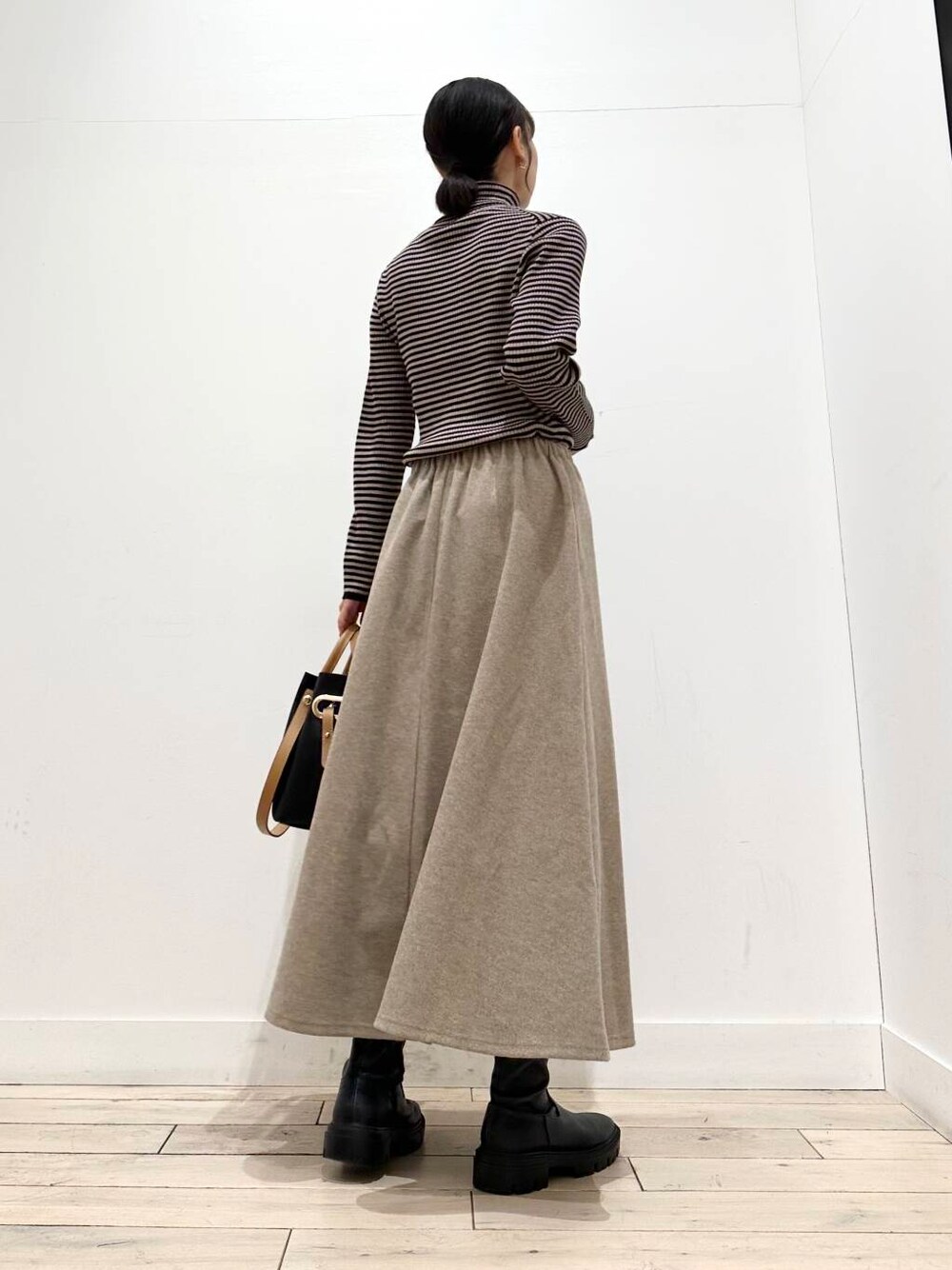 ブラック系のトートバッグ、ブラック系のブーツ、その他のニット/セーターを着用したレディースの冬コーディネートの3枚目の写真