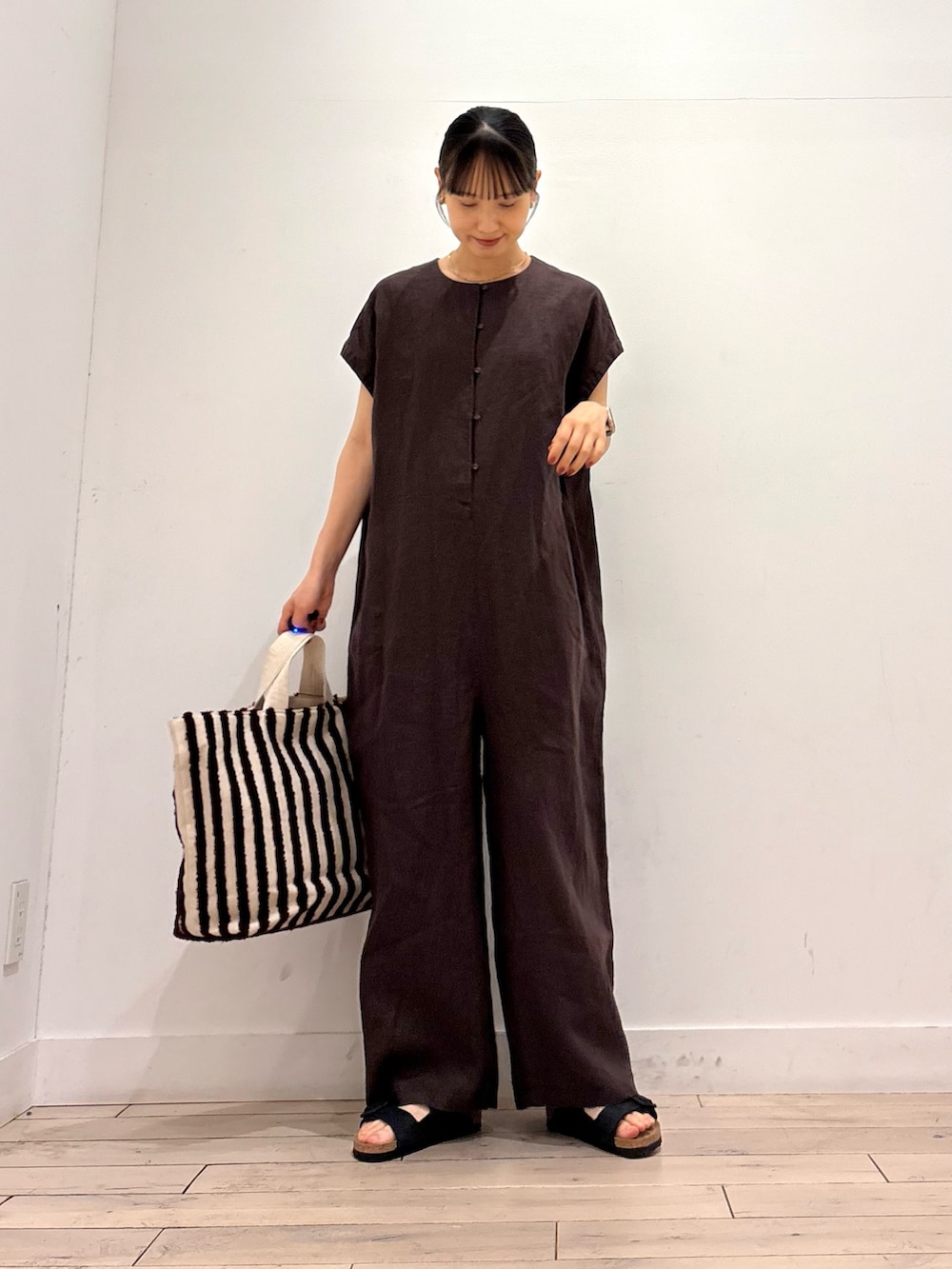 グレー系のその他パンツ、ブラウン系のトートバッグ、ブラック系のサンダルを着用したレディースの夏コーディネートの2枚目の写真