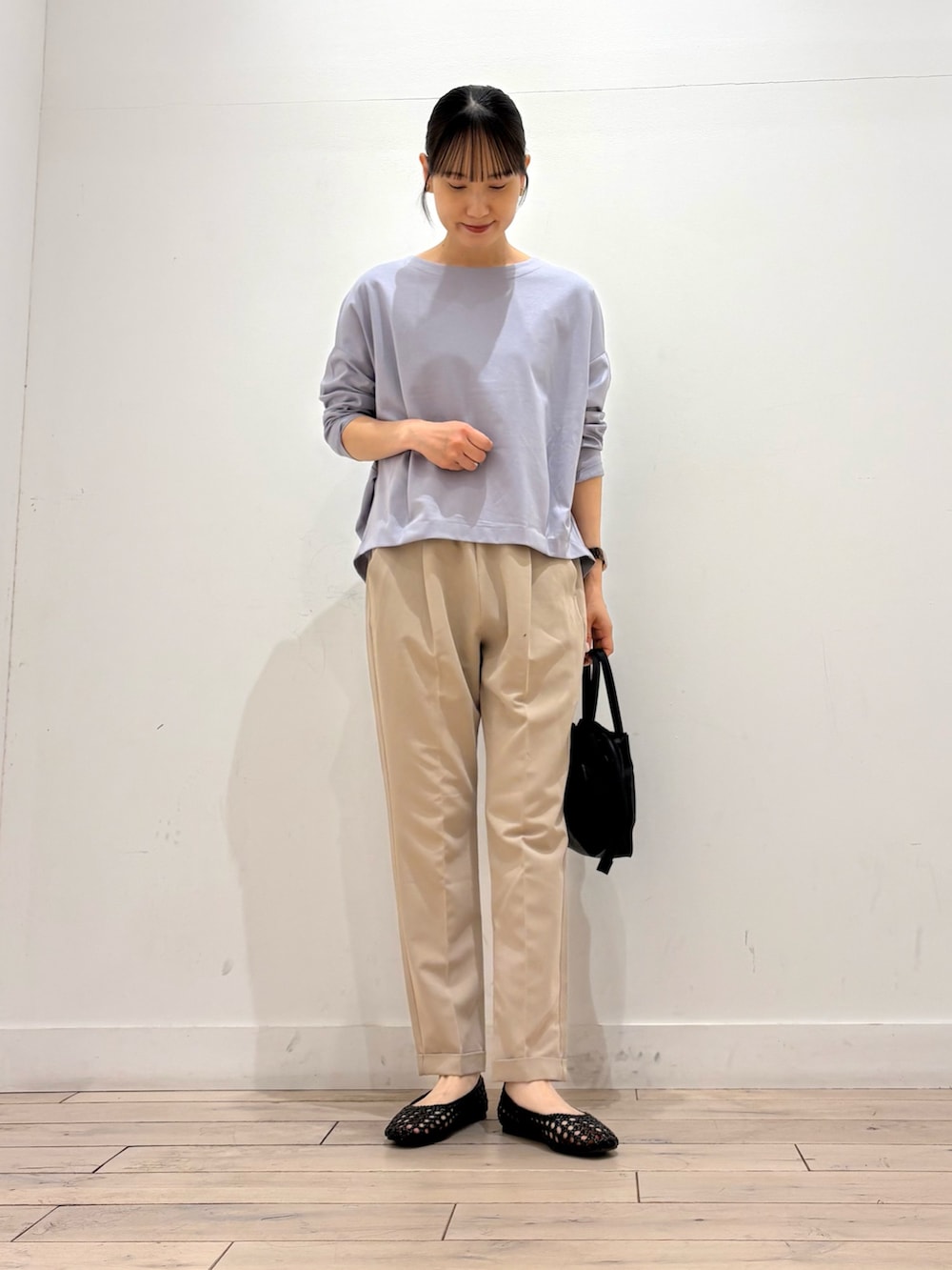 パープル系のTシャツ/カットソー、ベージュ系のその他パンツ、ブラック系のショルダーバッグを着用したレディースの春コーディネートの2枚目の写真