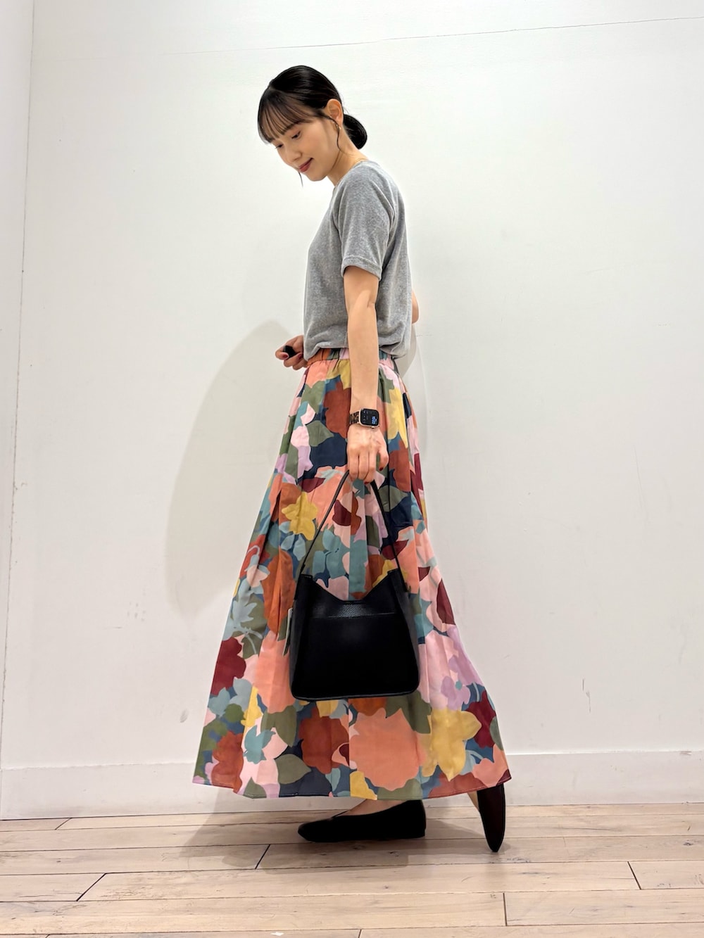 グレー系のTシャツ/カットソー、ピンク系のスカート、ブラック系のハンドバッグを着用したレディースの夏コーディネートの2枚目の写真