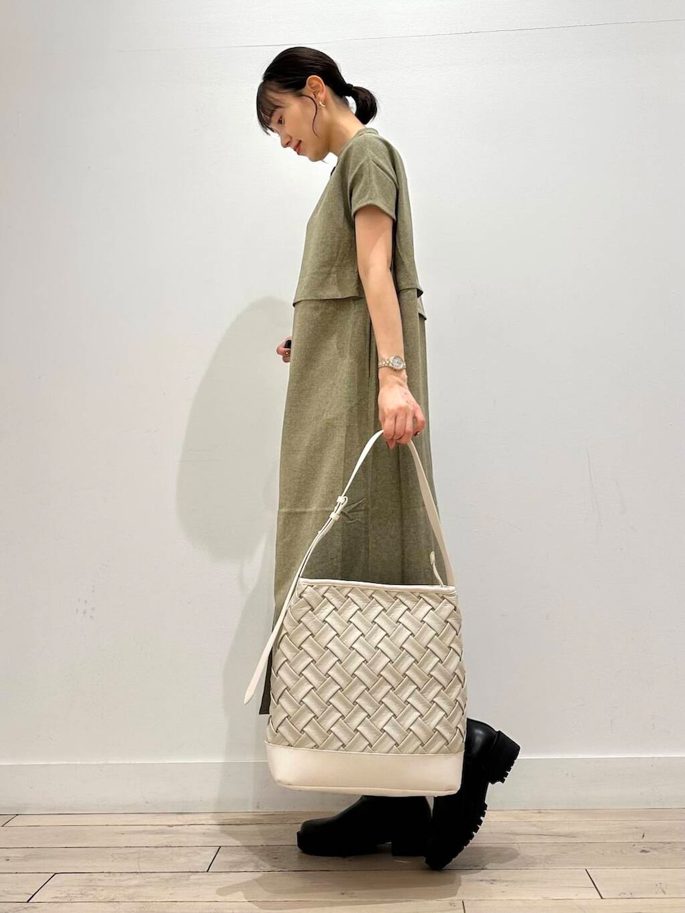 ホワイト系のトートバッグ、グリーン系のワンピース、ブラック系のブーツを着用したレディースの夏コーディネートの4枚目の写真