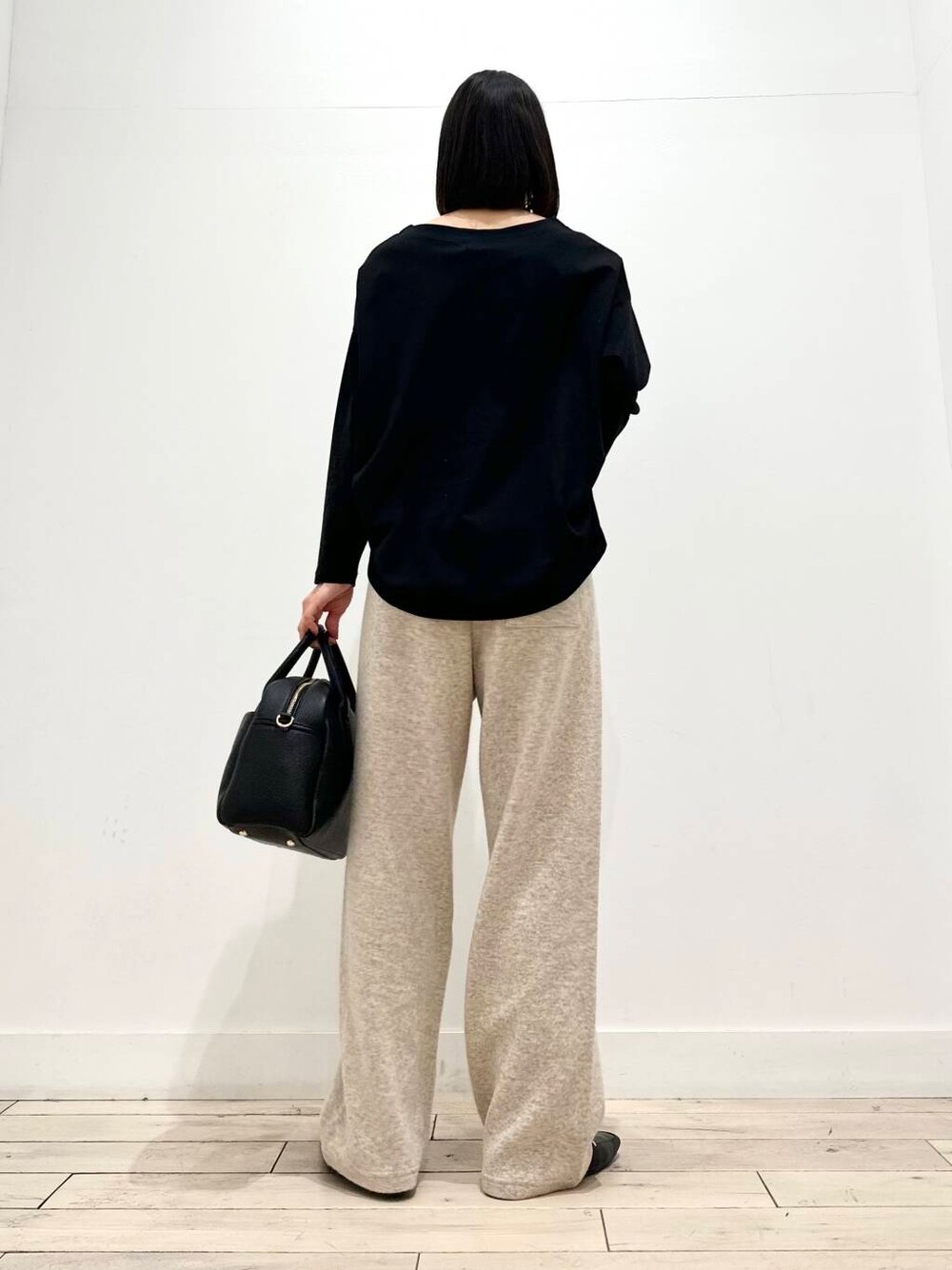 ブラック系のローファー、ブラック系のTシャツ/カットソー、ブラック系のボストンバッグを着用したレディースの秋コーディネートの3枚目の写真