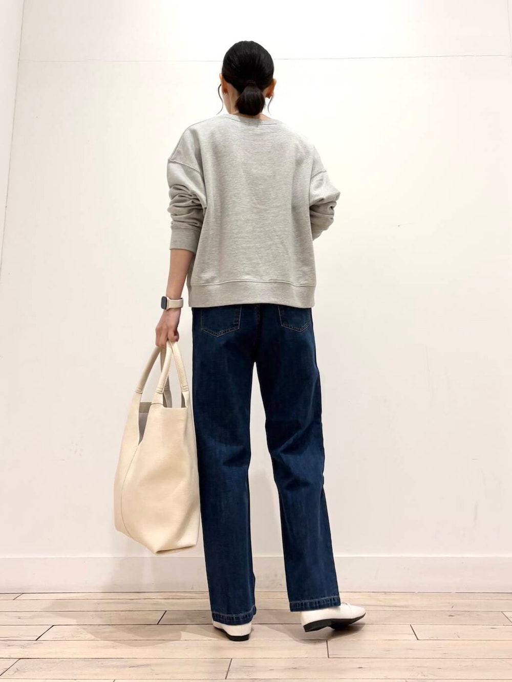 ブルー系のデニムパンツ、ブラック系のマウンテンパーカー、ホワイト系のローファーを着用したレディースの春コーディネートの7枚目の写真