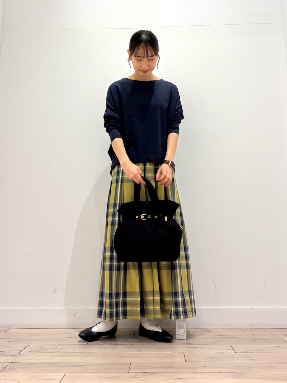 ブルー系のTシャツ/カットソー、イエロー系のスカート、ブラック系のトートバッグを着用したレディースの秋コーディネートの2枚目の写真