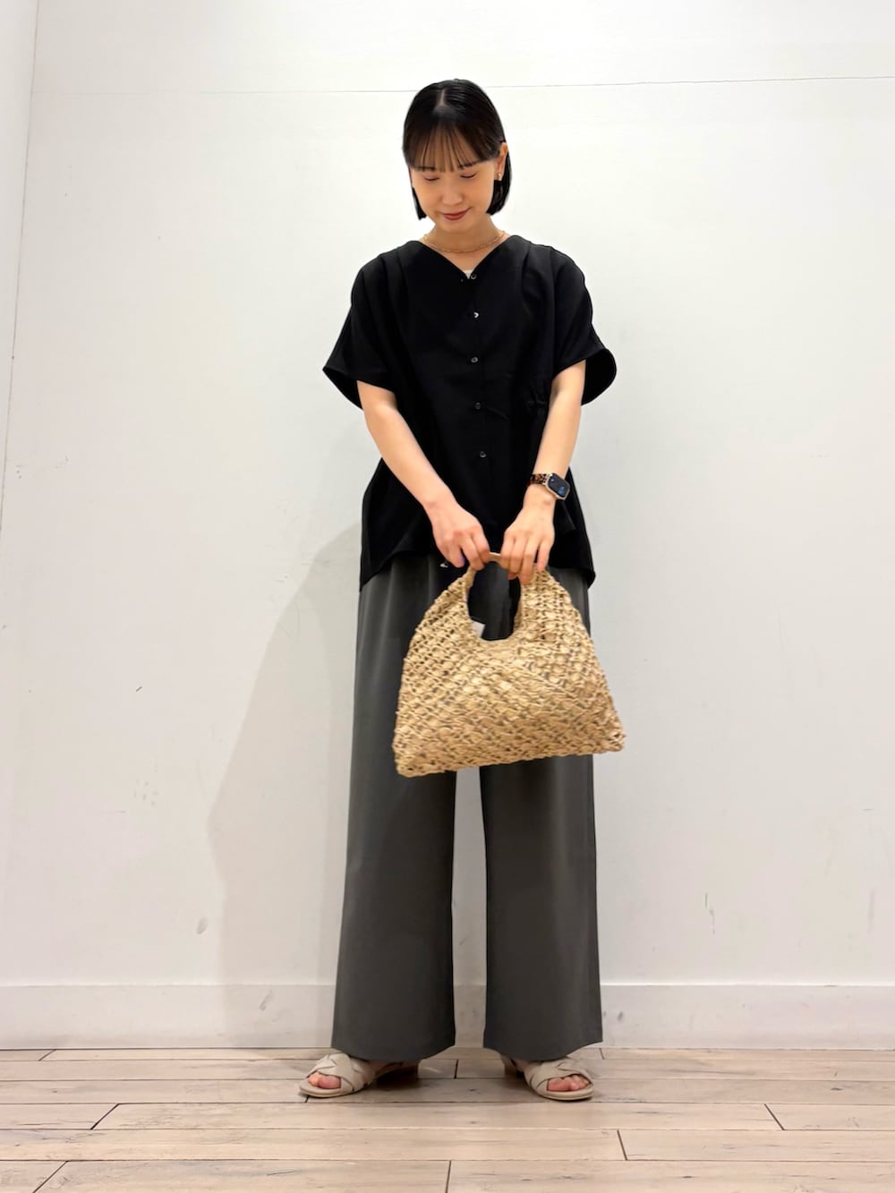 ブラック系のシャツ/ブラウス、ベージュ系のハンドバッグ、グレー系のその他パンツを着用したレディースの夏コーディネートの2枚目の写真