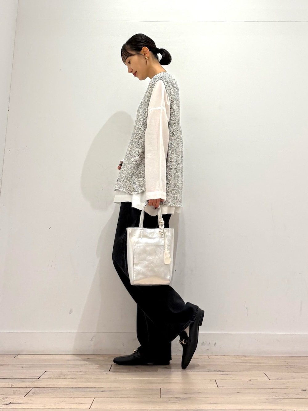 ホワイト系のシャツ/ブラウス、ブラック系のデニムパンツ、シルバー系のトートバッグを着用したレディースの秋コーディネートの4枚目の写真