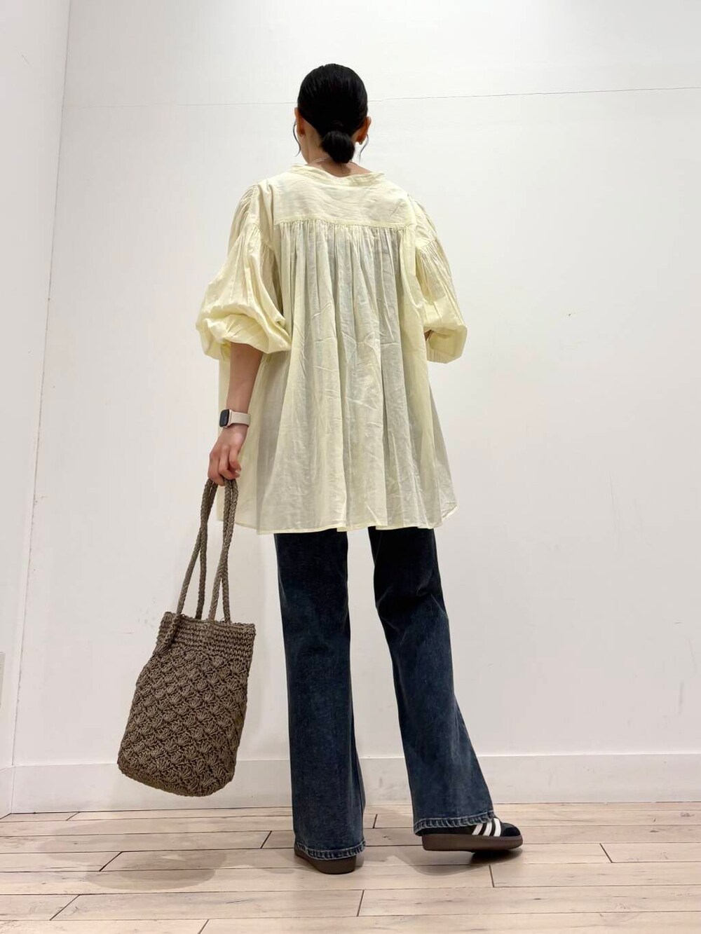ブルー系のデニムパンツ、グレー系のトートバッグ、イエロー系のシャツ/ブラウスを着用したレディースの春コーディネートの4枚目の写真