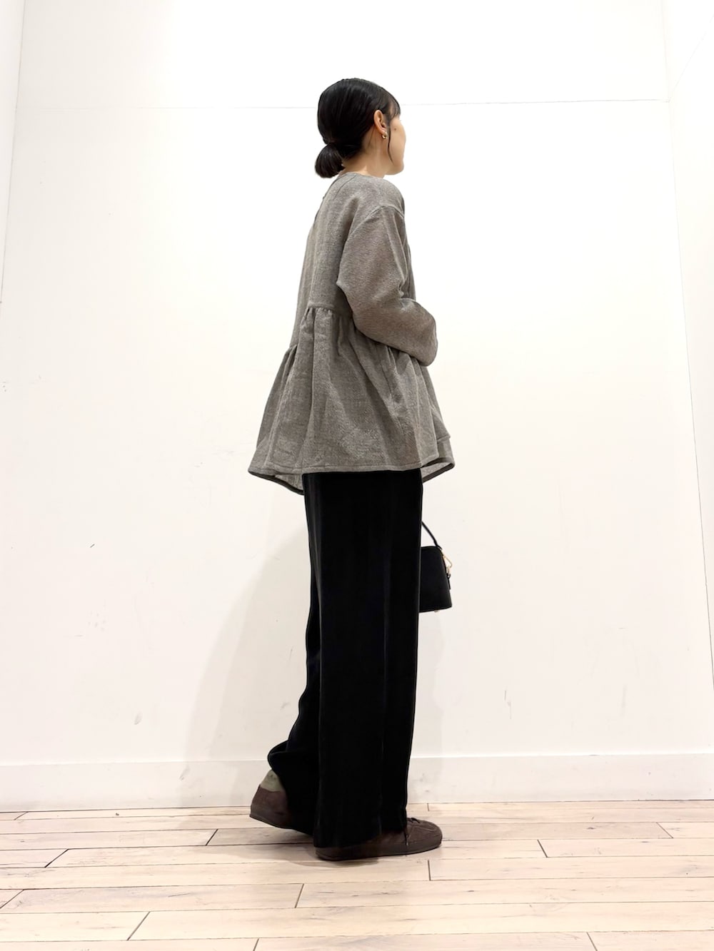 グレー系のシャツ/ブラウス、ブラウン系のスニーカー、ブラック系のショルダーバッグを着用したレディースの秋コーディネートの3枚目の写真