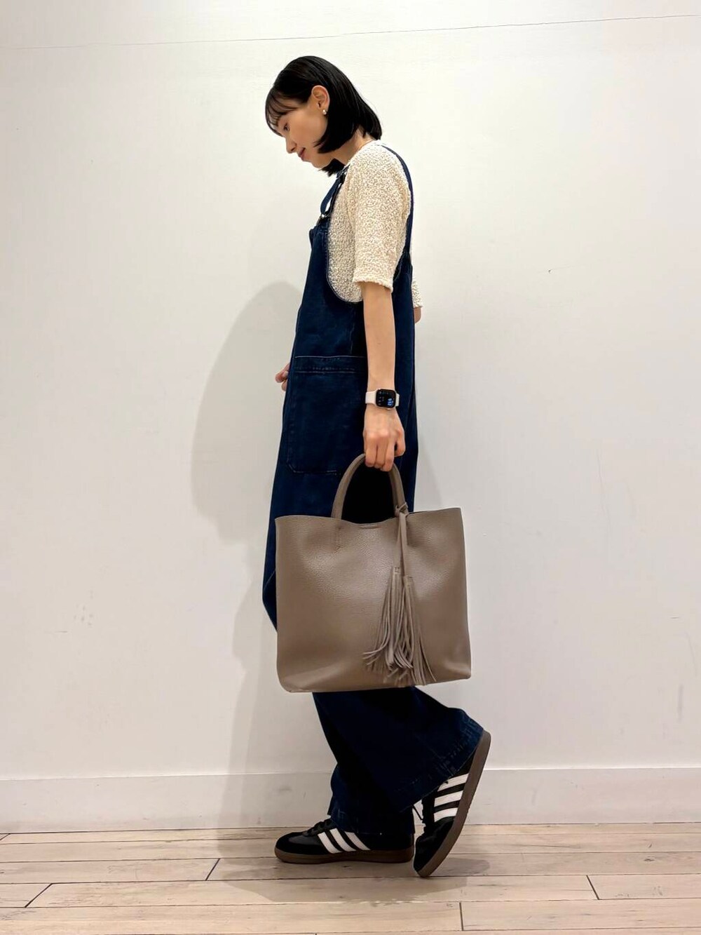 ブルー系のサロペット/オーバーオール、グレー系のトートバッグ、ホワイト系のノーカラージャケットを着用したレディースの春コーディネートの2枚目の写真